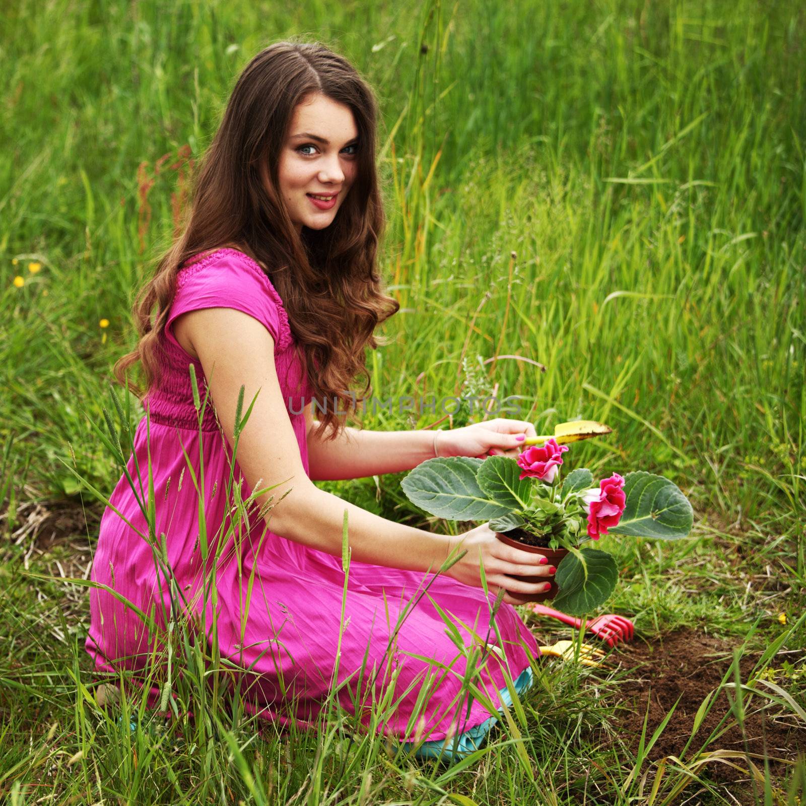 girl grow flower on green field