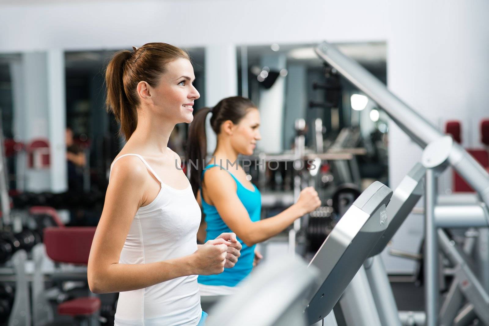 women running on a treadmill in a fitness club, sport in the fitness club
