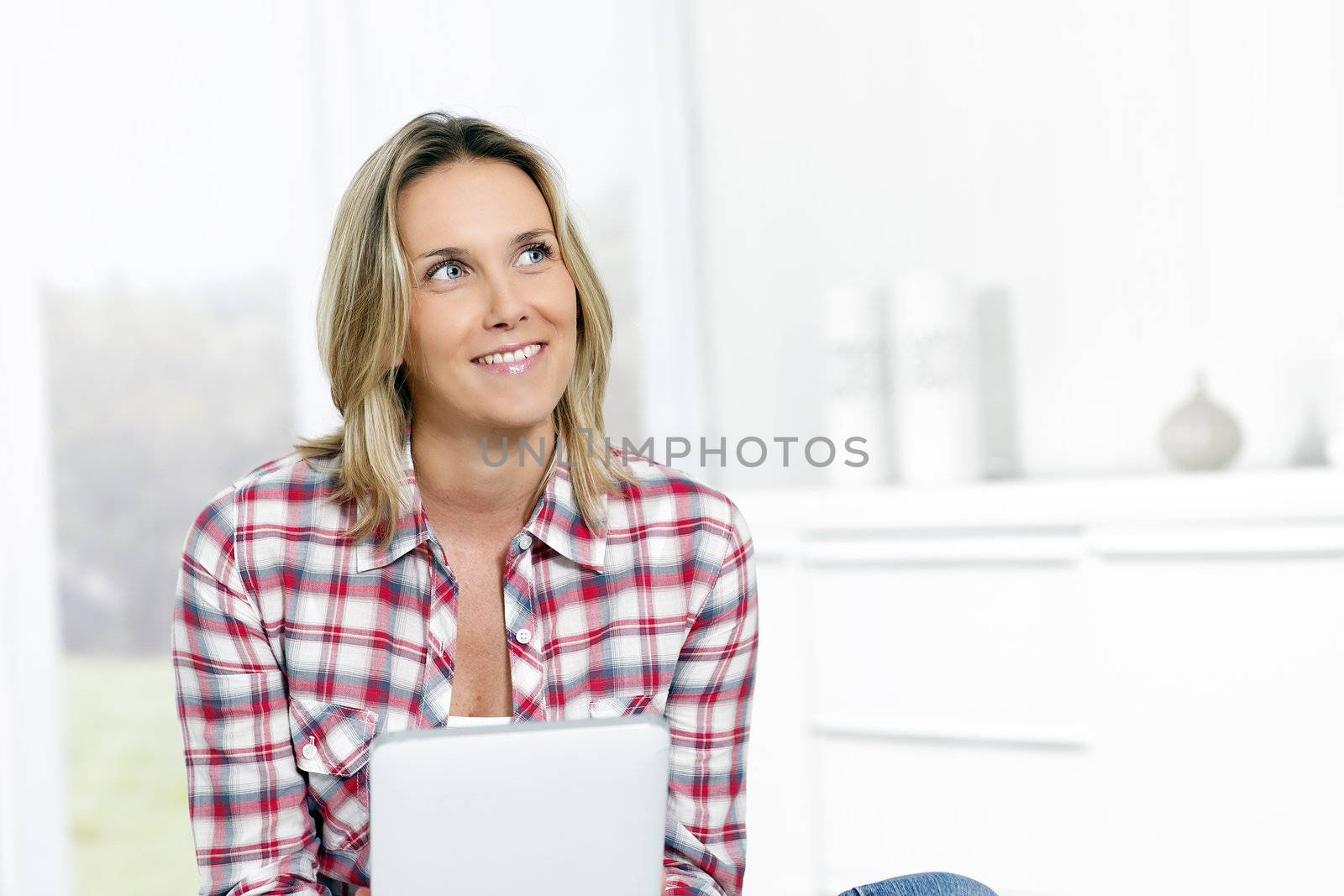 woman at home with tablet looking at someone