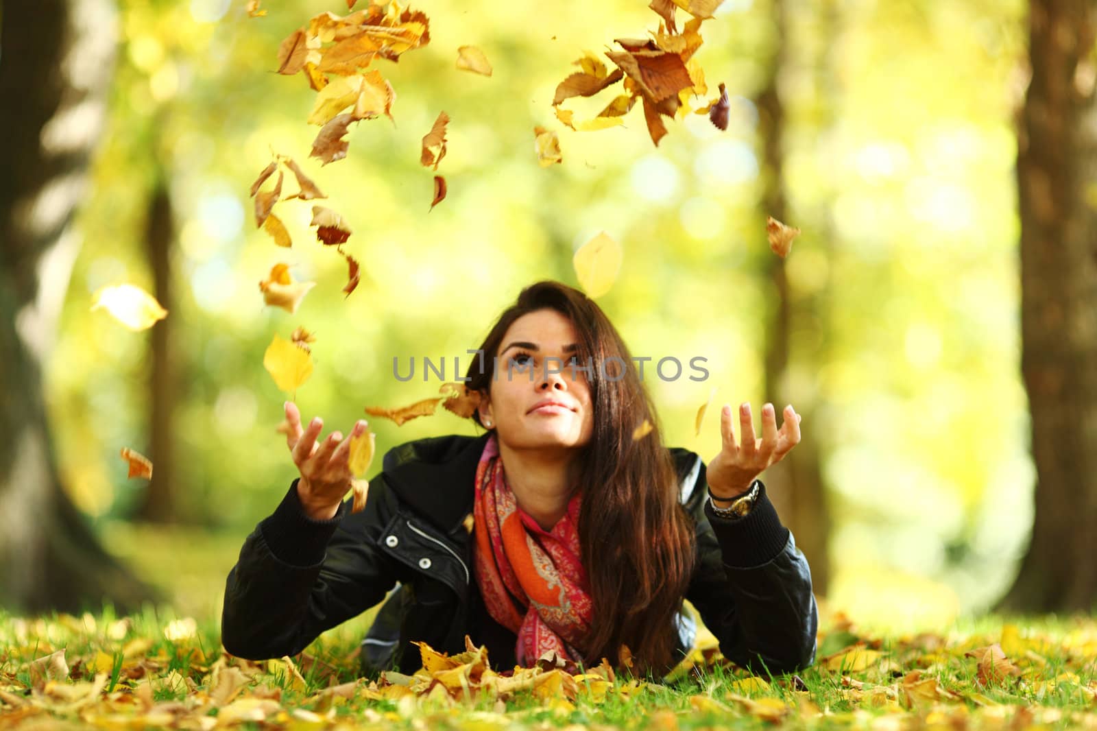 woman drop leaves in autumn park by Yellowj