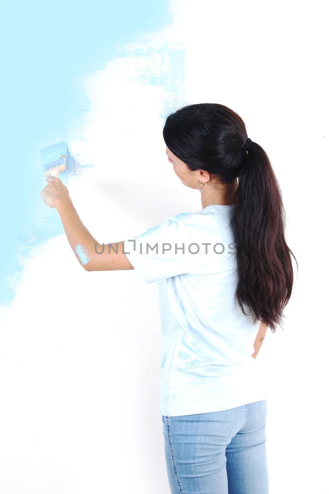 woman paints the wall brush