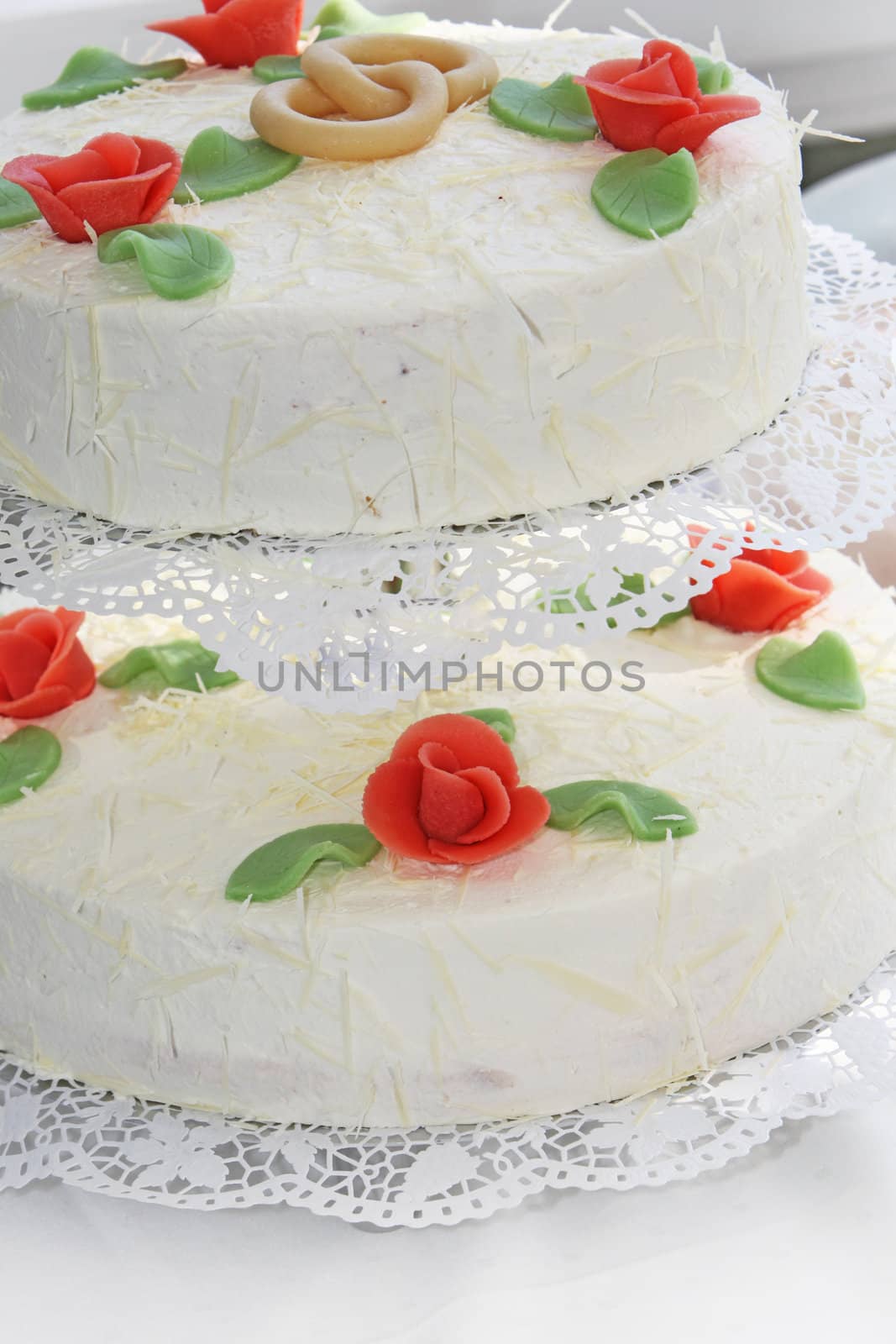 Detail of intertwined rings with pretty rose buds on a wedding cake