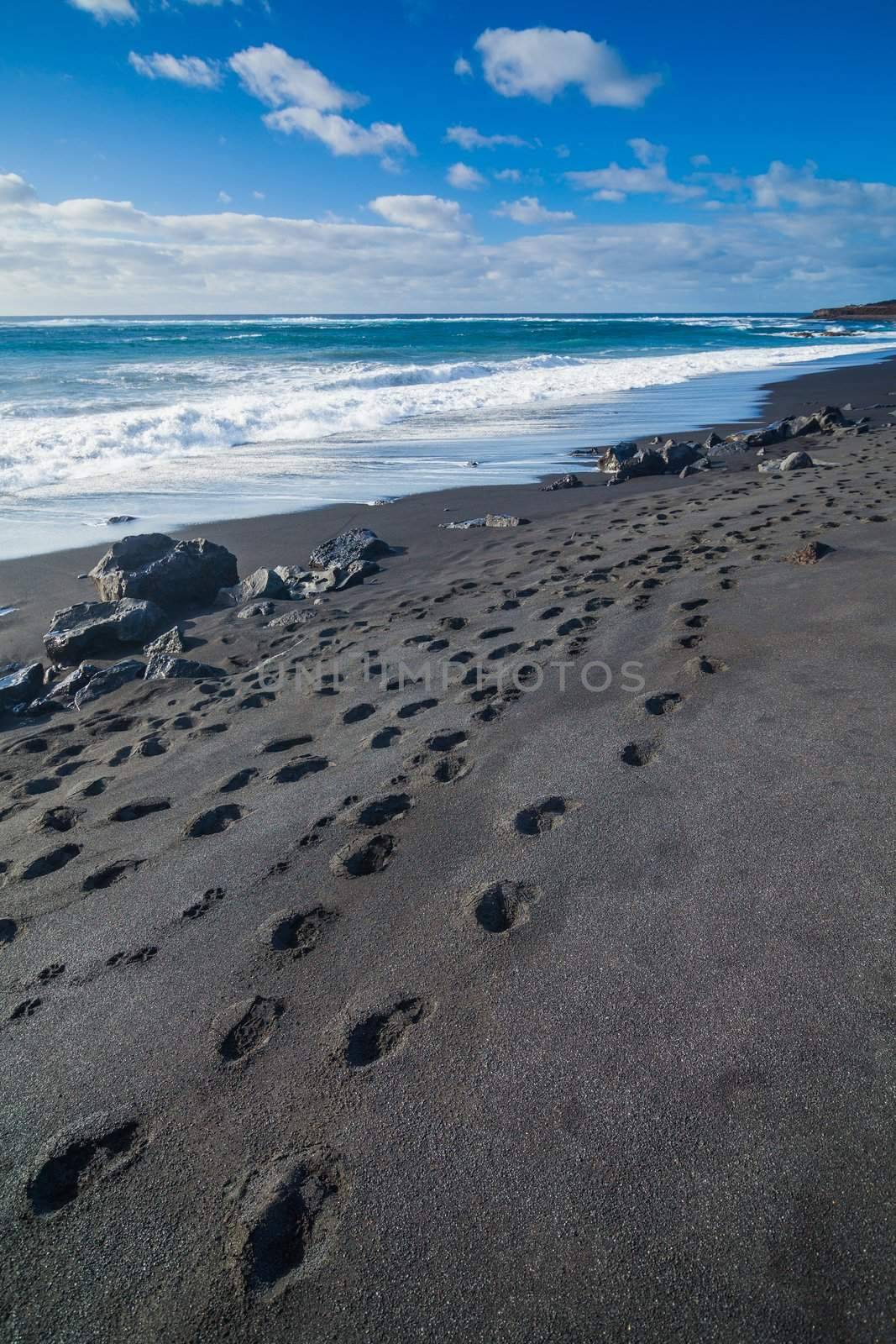 Exotic beach with black sand and footprints on Lanzarote, Canary islands, Spain