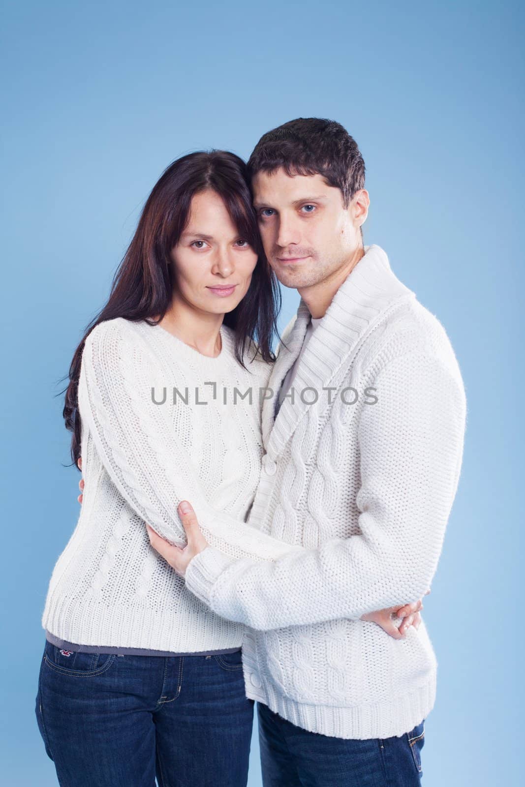 Portrait of a romantic young couple standing together in studio