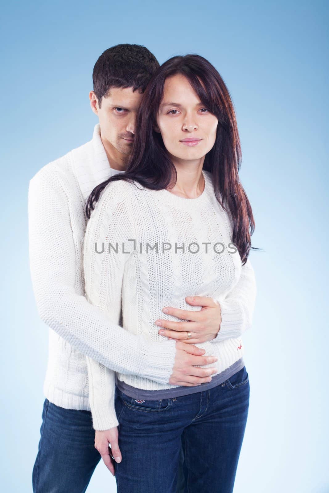 Portrait of a romantic young couple standing together in studio