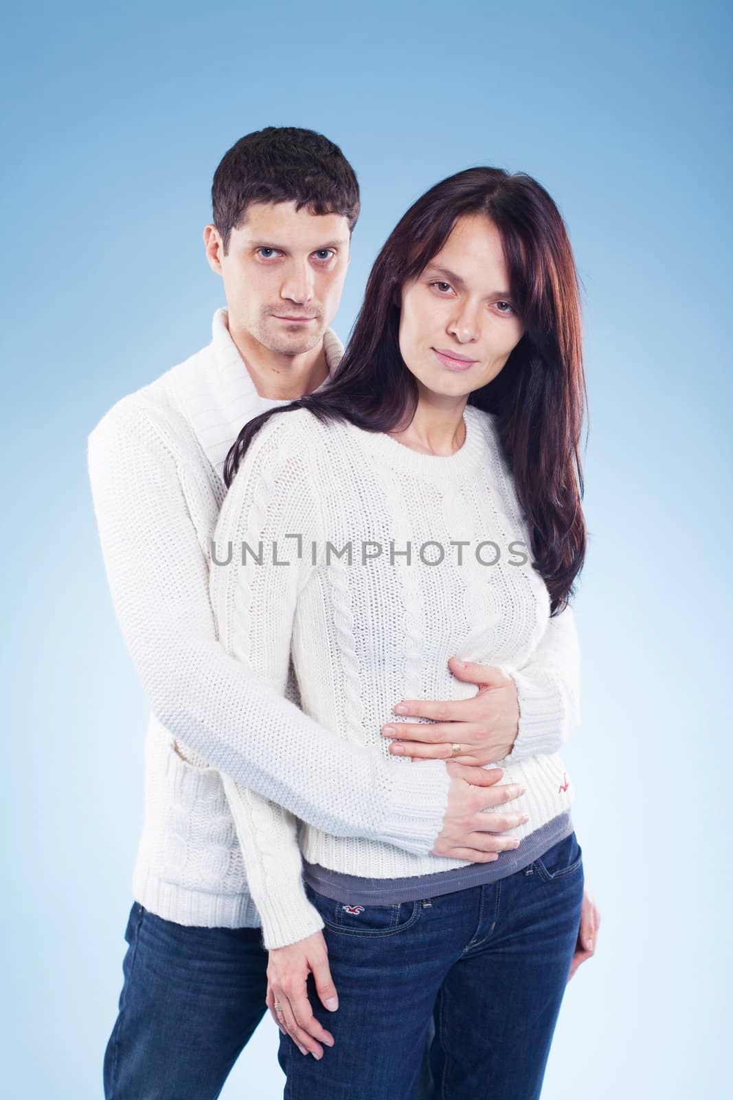 Portrait of a romantic young couple standing together in studio