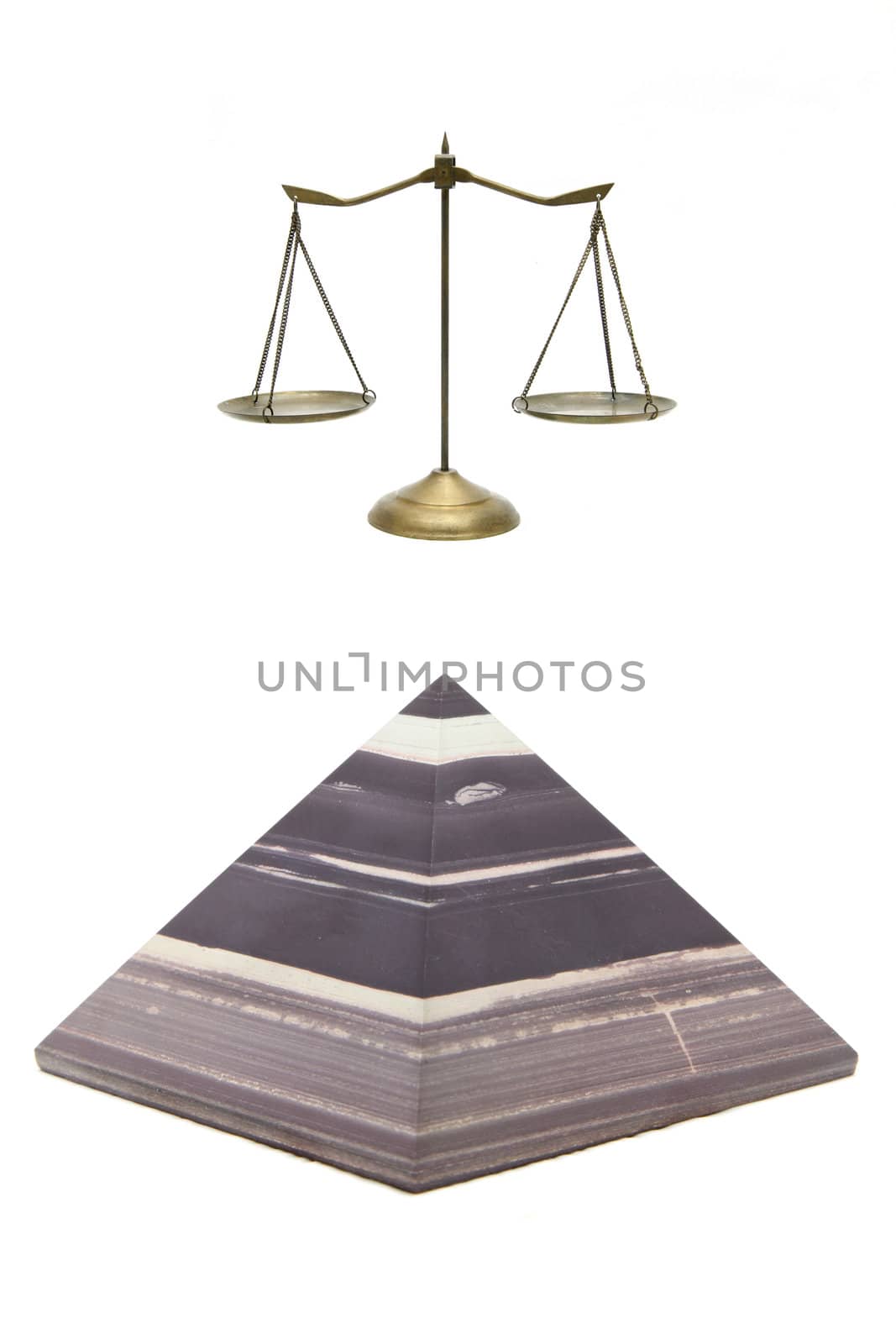 isolated brown stone pyramid and golden scale on white