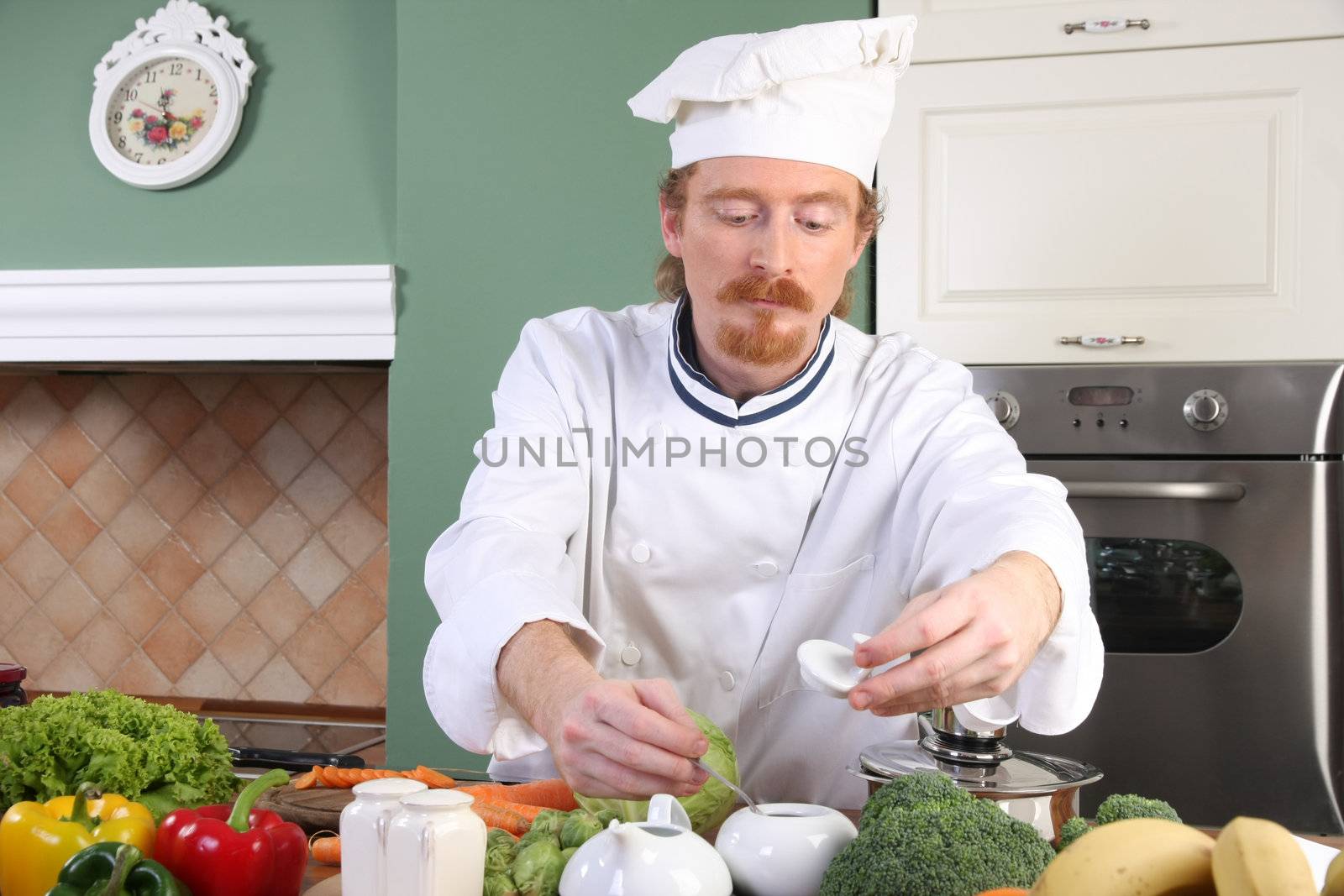 Young chef with vegetables, preparing lunch in kitchen