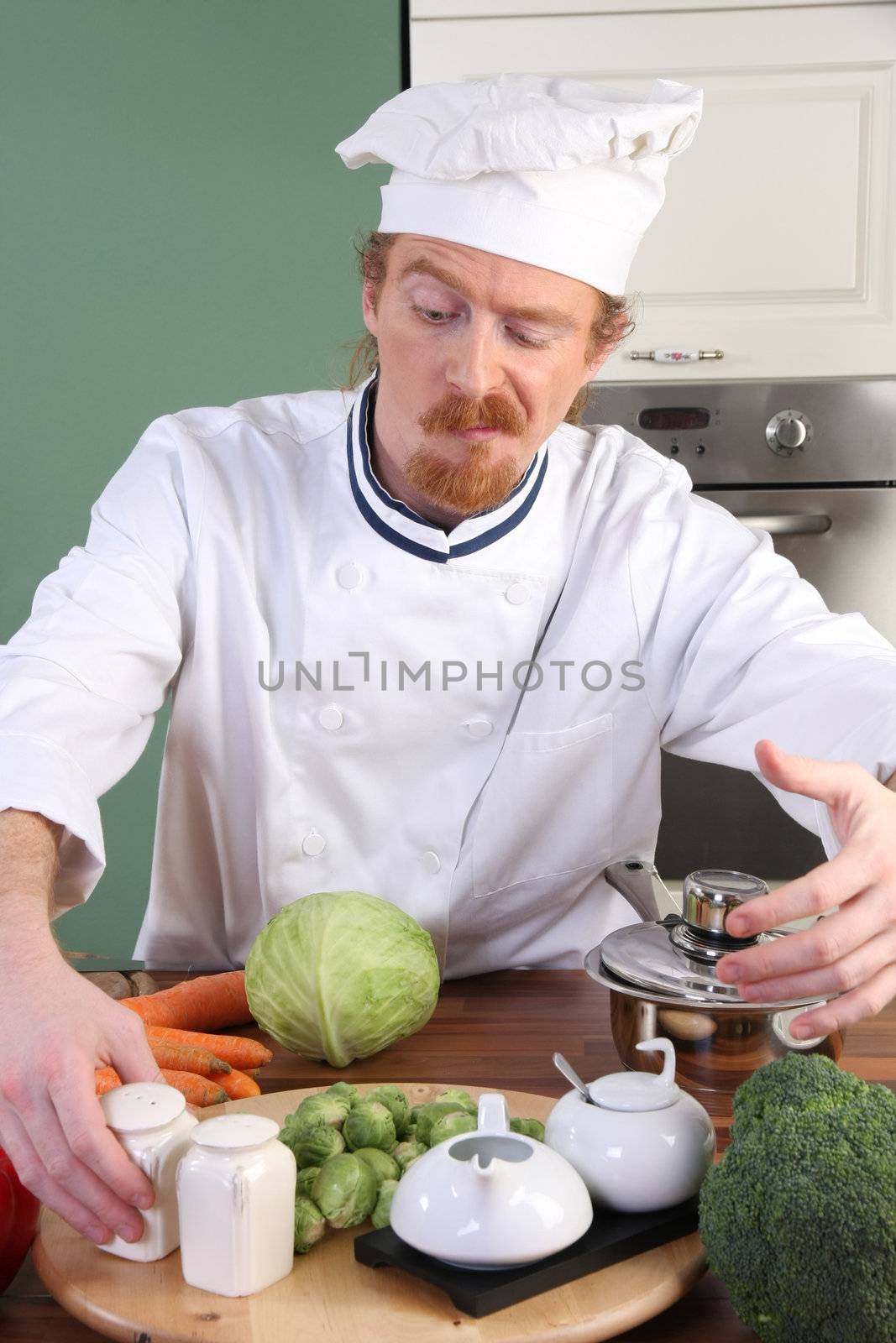 Funny young Chef takes the salt, preparing lunch in kitchen