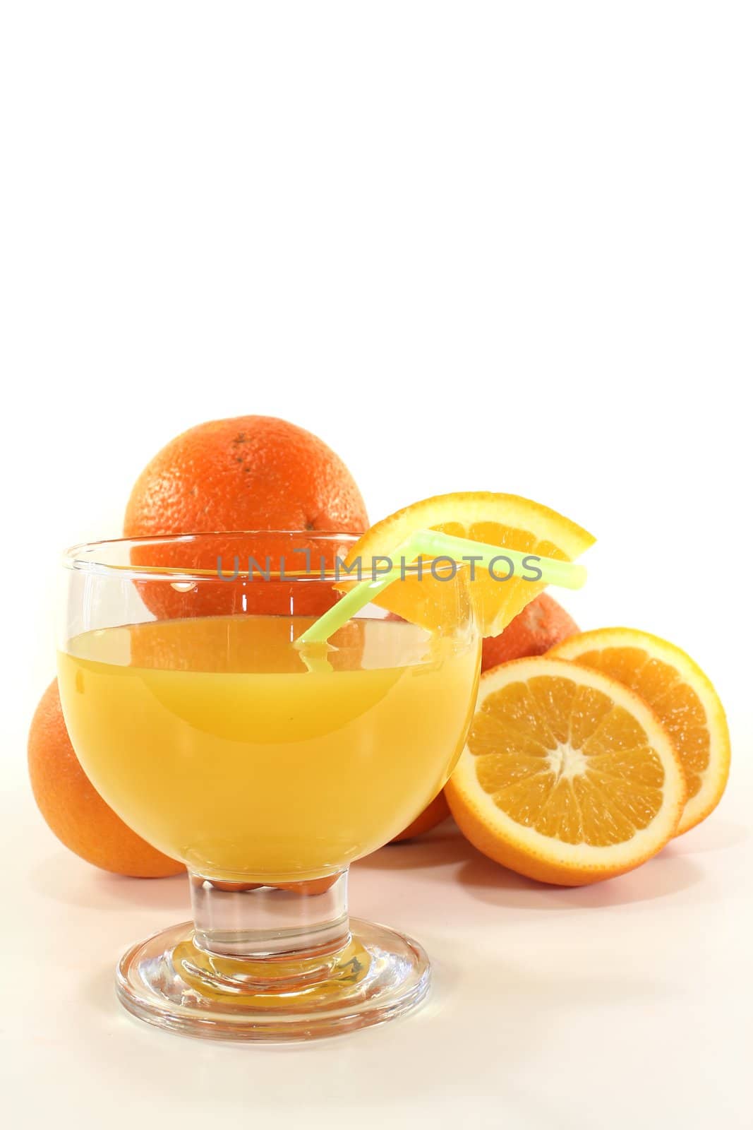 freshly squeezed orange juice with orange halves on a light background