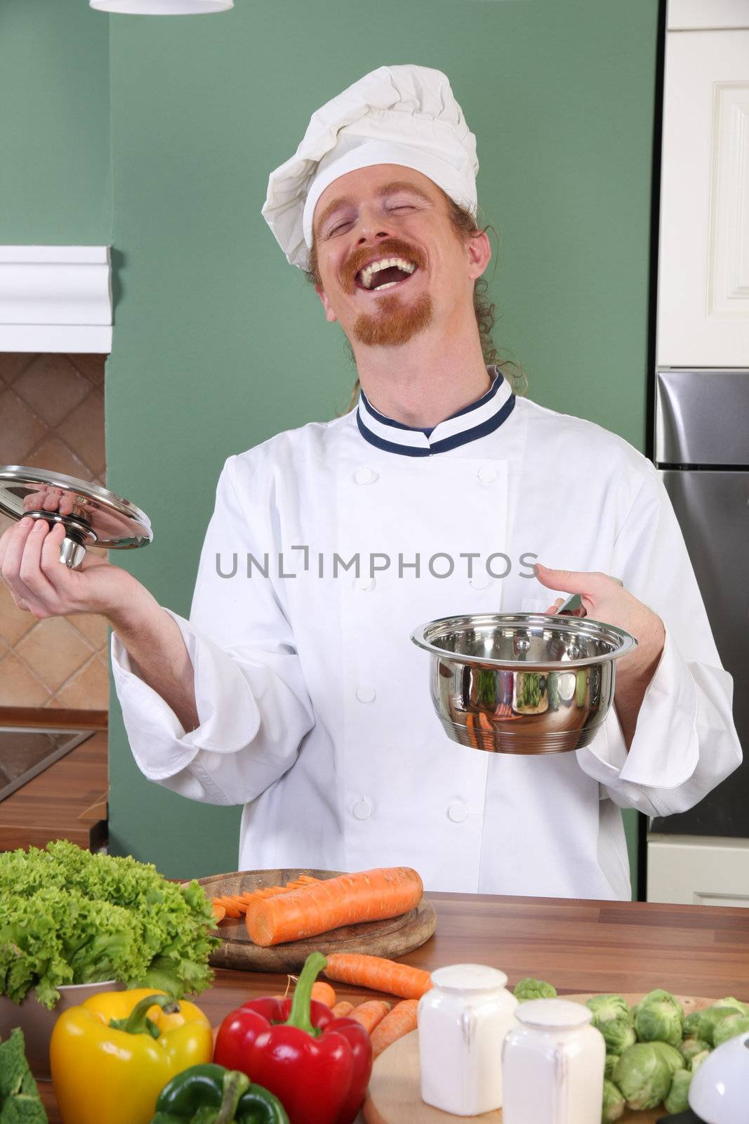 Young chef with vegetables, preparing lunch in kitchen