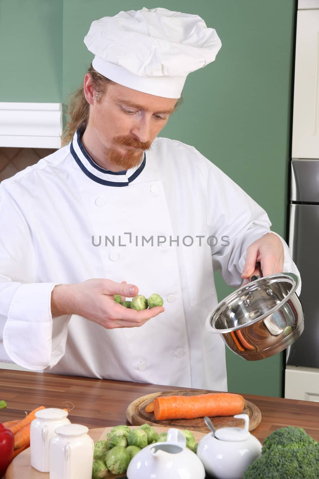 Young Chef with Brussels sprouts, preparing lunch in kitchen