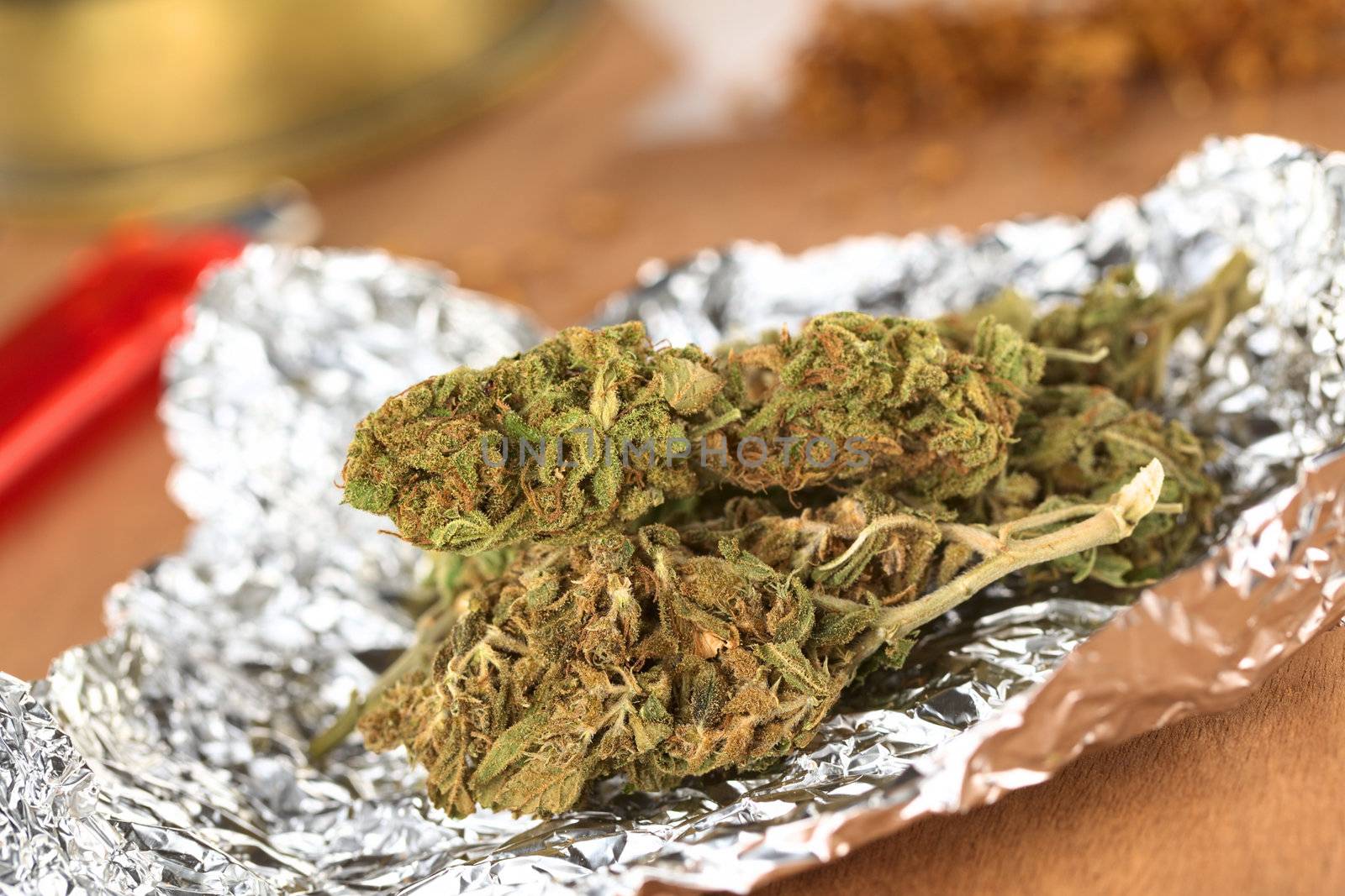 Dried flowers of Cannabis sativa on tinfoil (Selective Focus, Focus on the front of the two heads in the front) 