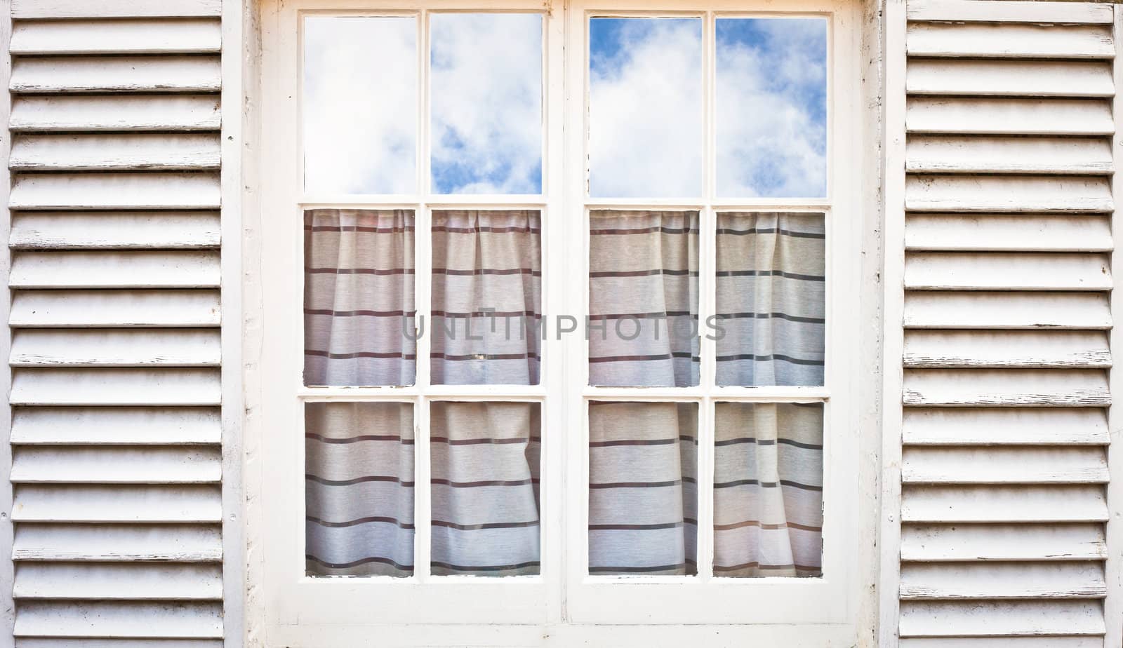 White wooden wndow frame with blue cloudy sky