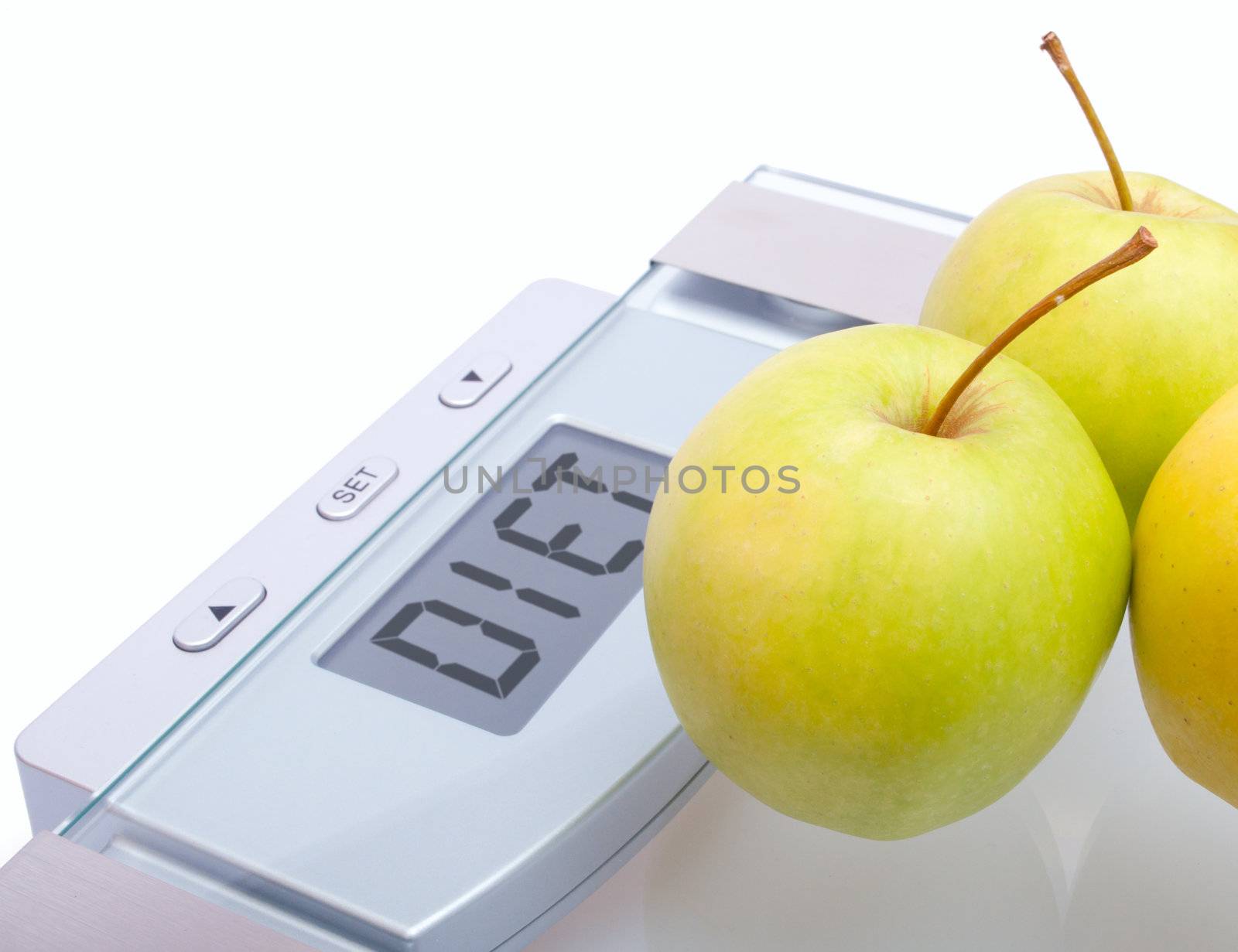 Diet - Green Apples on Bathroom Scales With Diet Sign on Display on White Background