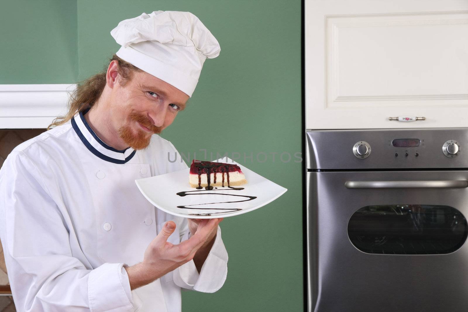 Young chef with piece of cake with chocolate sauce