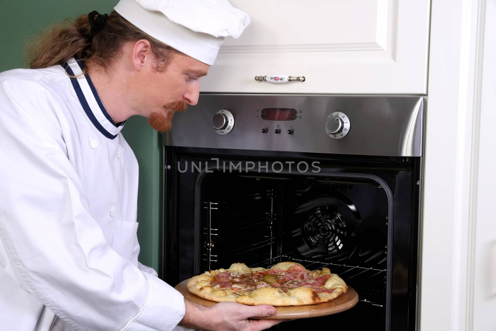 Young chef prepared italian pizza in kitchen by vladacanon