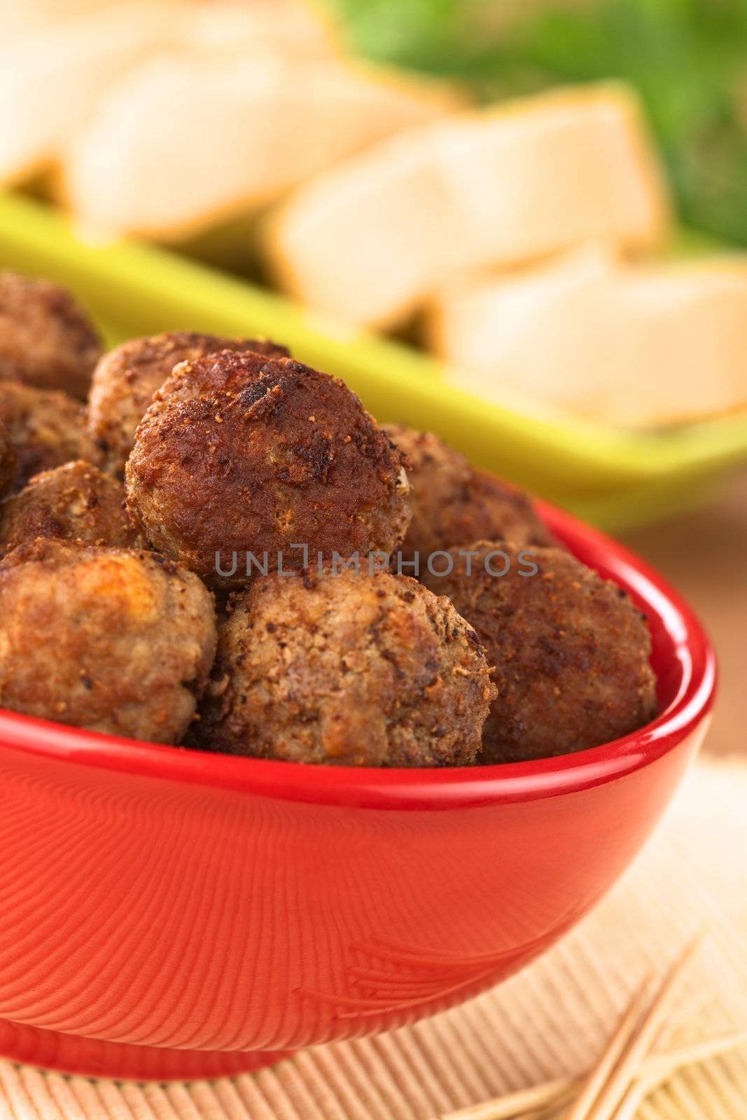 Meatball appetizers in a bowl with baguette slices (Selective Focus, Focus on the meatball on the top)