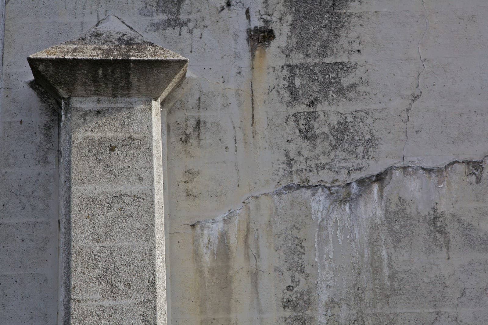 Formed angular concrete pillar in a large wall with lots of copy space