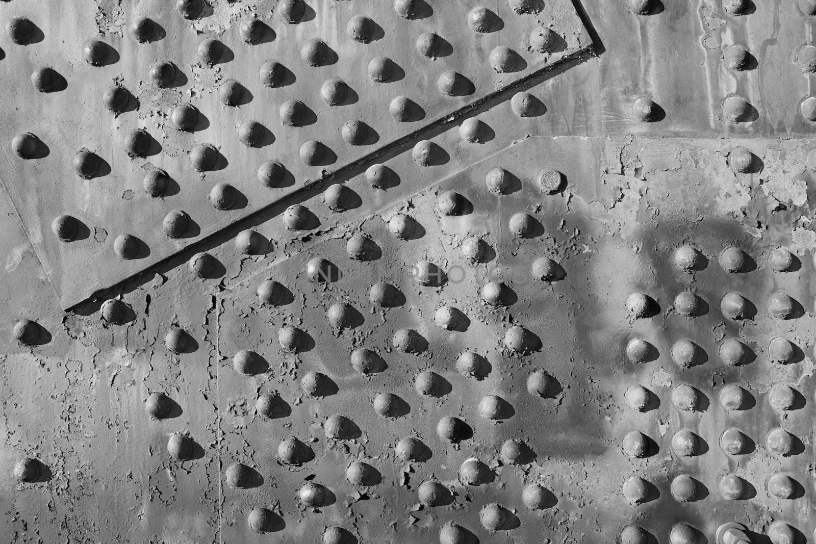 Black and white image close up of bridge structure showing weathered steel and rivets