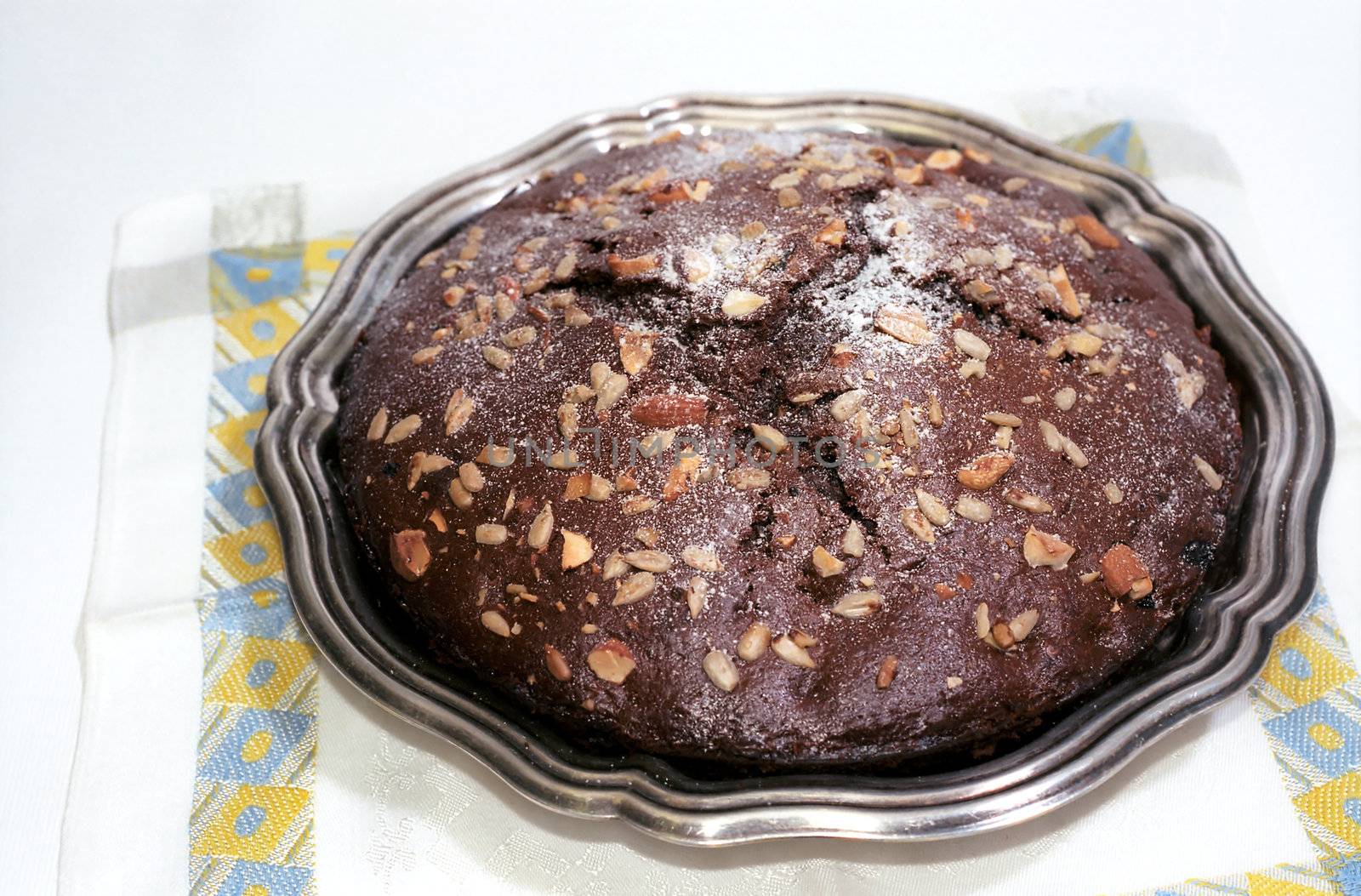 Chocolate cake with nuts and powdered sugar on table-napkin