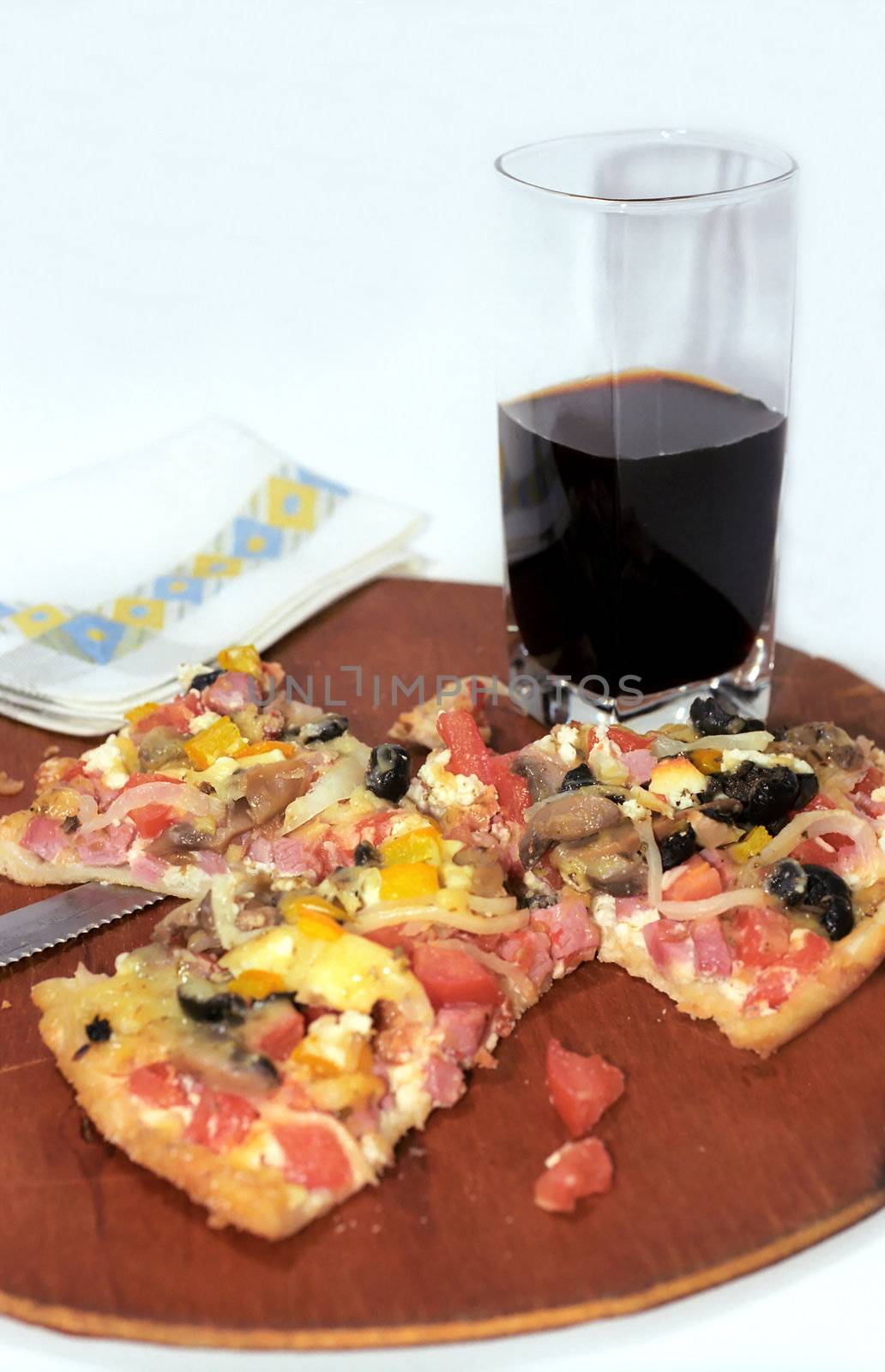 Cutting pizza and dark drink glass  by mulden