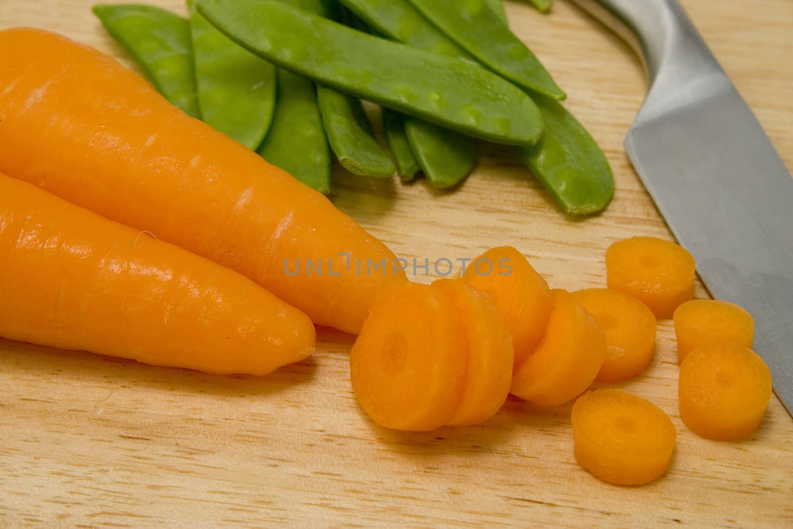 Carrots and peas on a chopping board