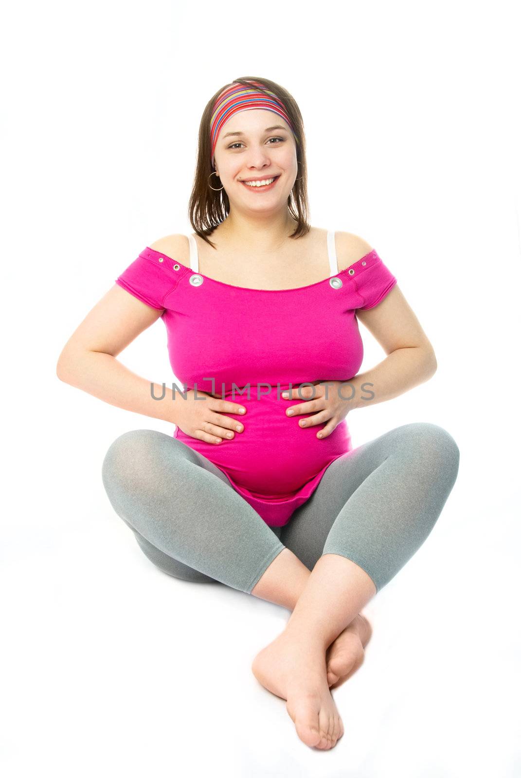 portrait of a beautiful happy pregnant woman sitting on the floor against white background