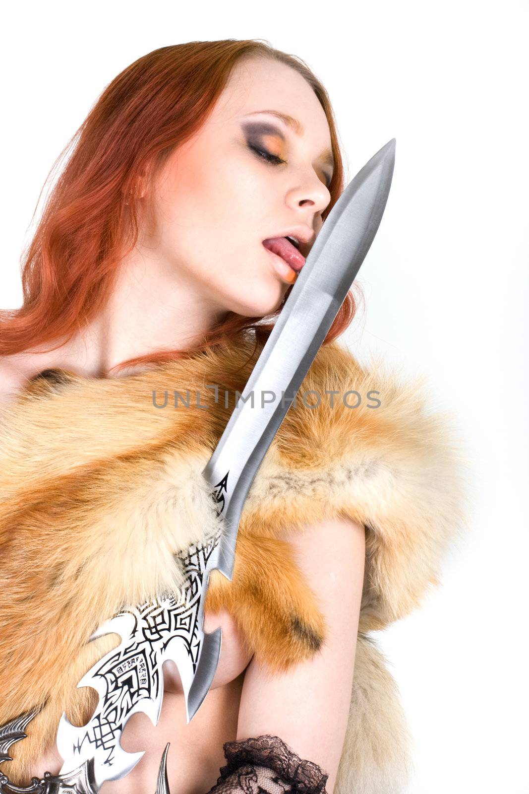 Young sexy redhair woman licking a sword