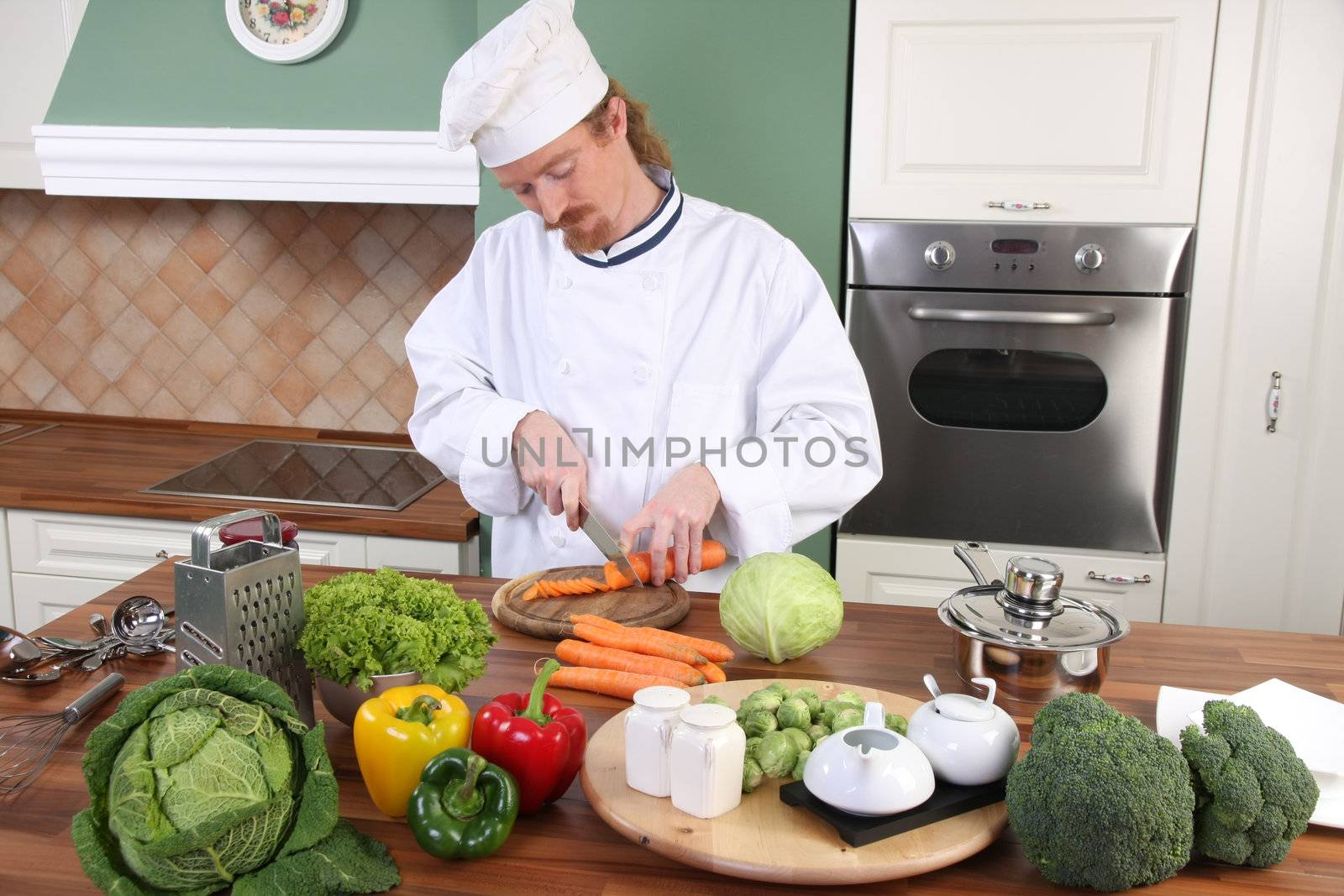Young chef with vegetables, preparing lunch in kitchen