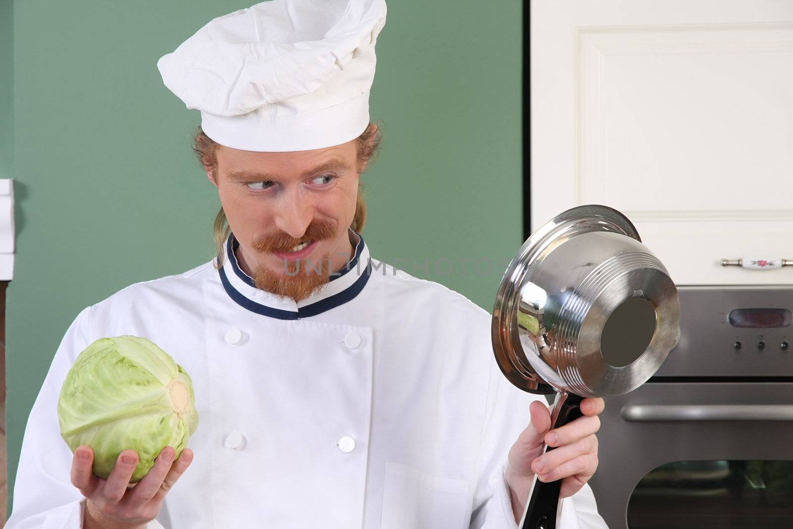 Young chef with cabbage, preparing lunch in kitchen