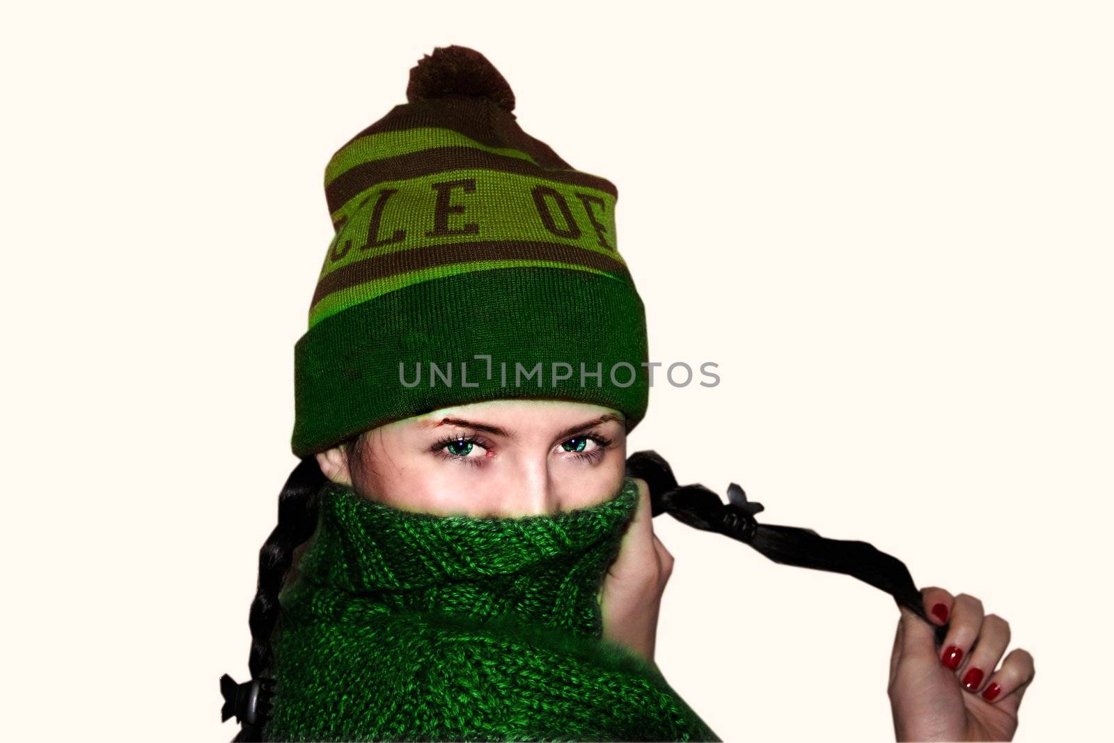 Young woman with green eyes in hat and a sweater covers part of the face