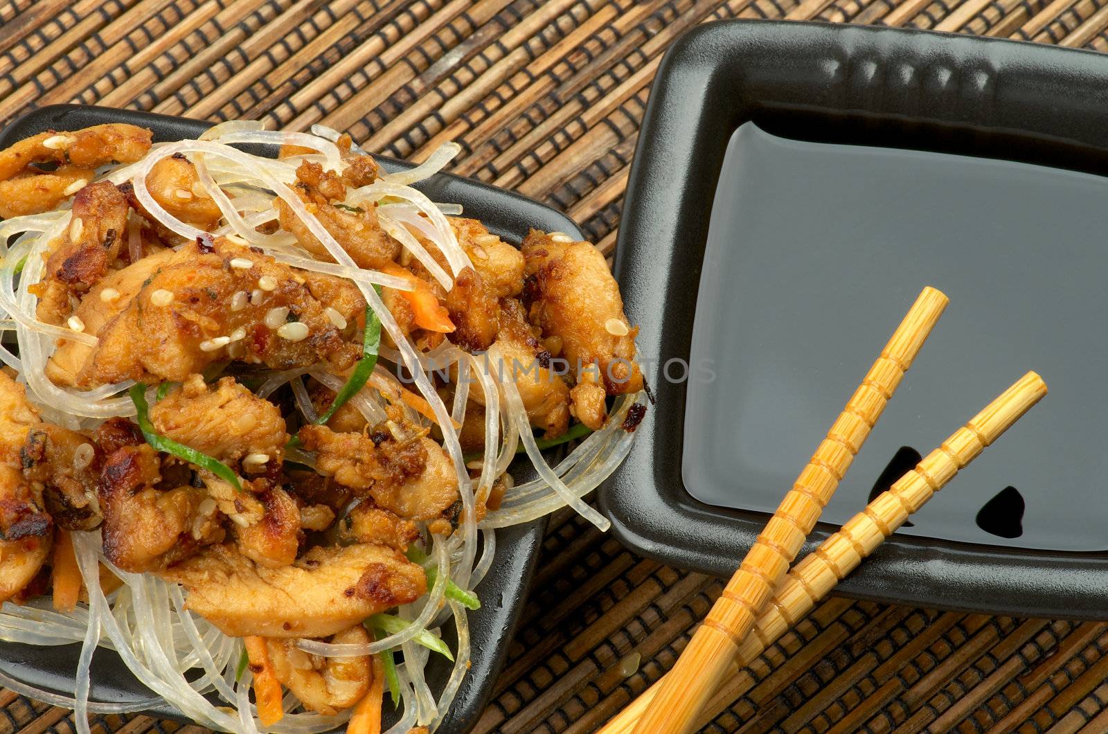 Chicken Teriyaki. Chinese Glass Noodles and Soy Sauce in Black Square Shape Bowls with Pair of Chopsticks on Straw mat background