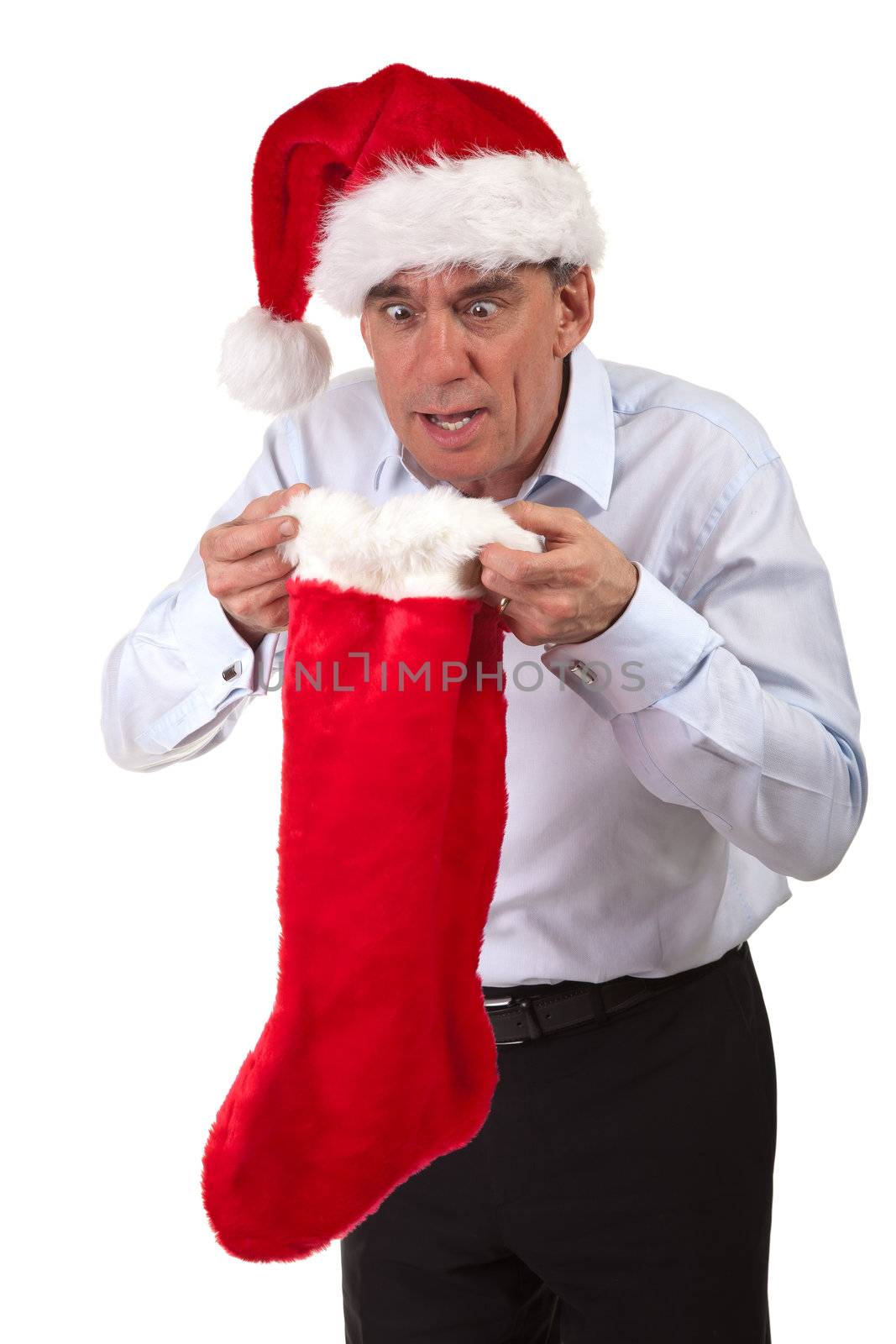 Middle Age Business Man in Santa Hat Looking Surprised into Christmas Stocking Isolated