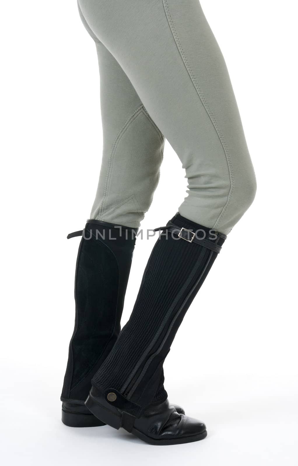 Woman wearing horse riding boots and breeches, on white background.