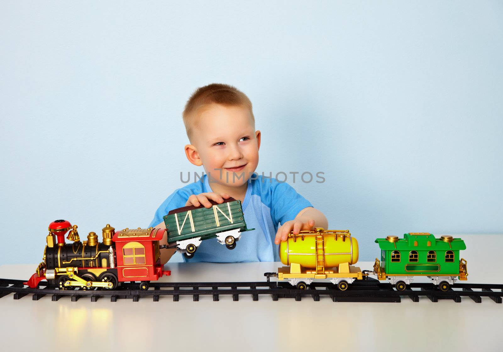 Boy playing with toy railroad at table