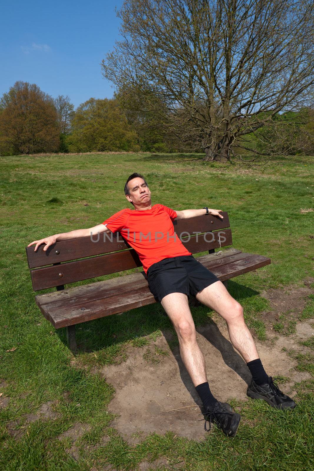 Tired Middle Age Man Exercising Resting on Sunny Park Bench