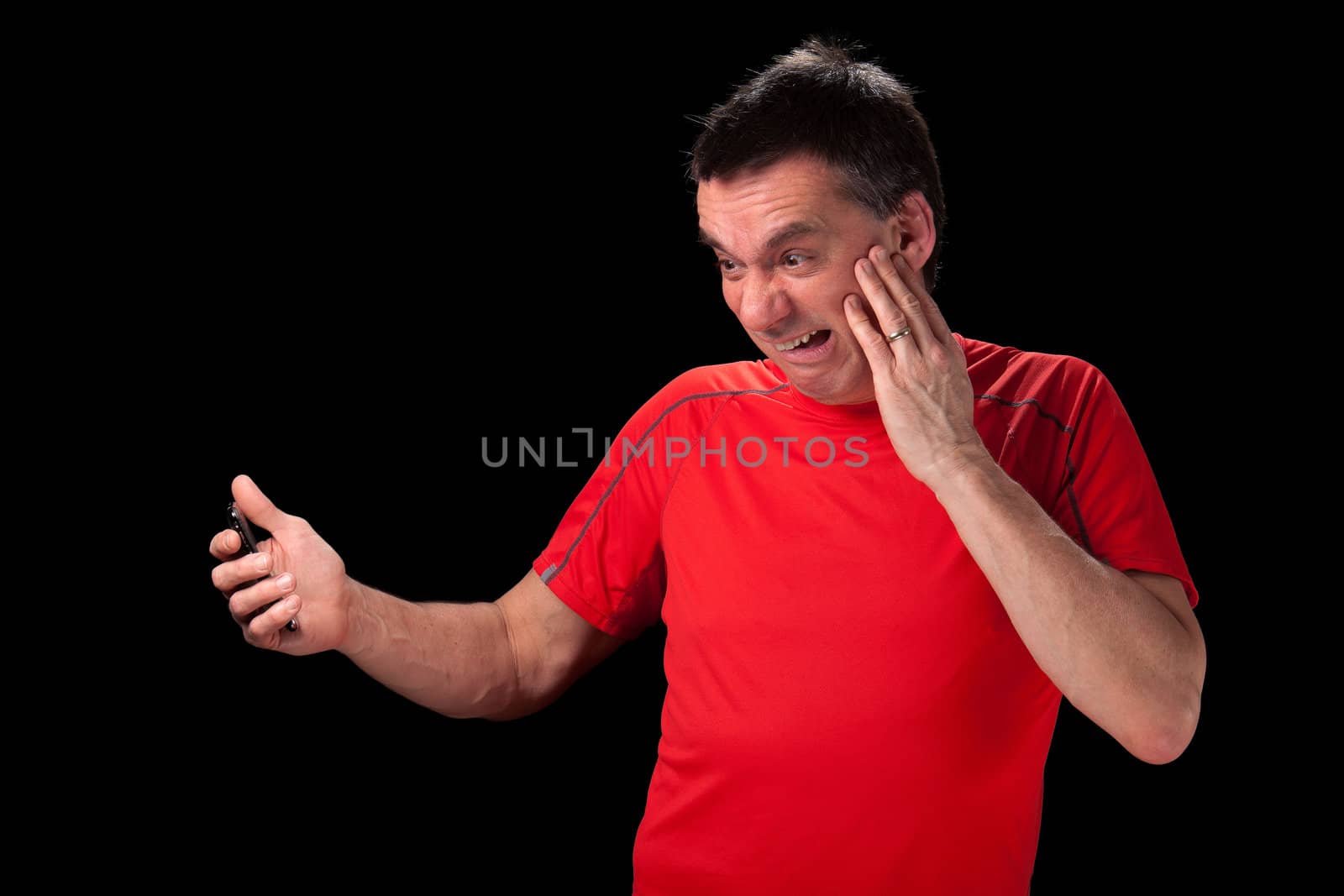 Middle Aged Man with horrified afraid expression looking at phone