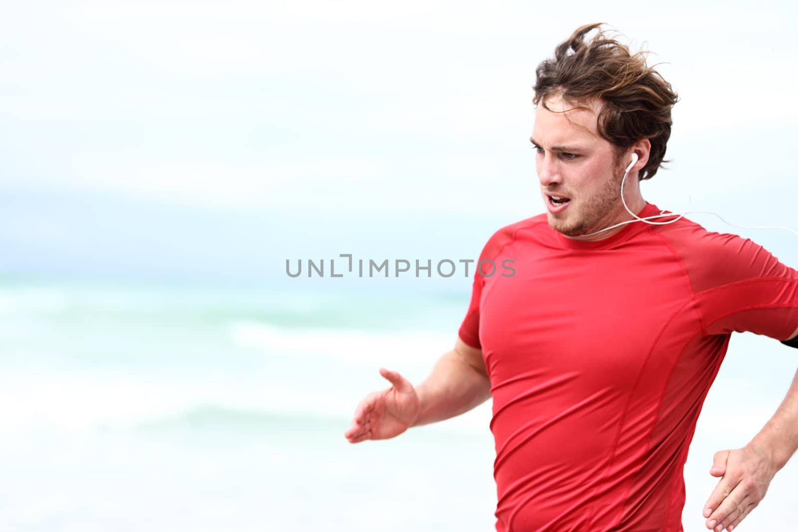 Running man. Runner athlete in outdoor workout sprint. Young sport man training outdoors in beach.
