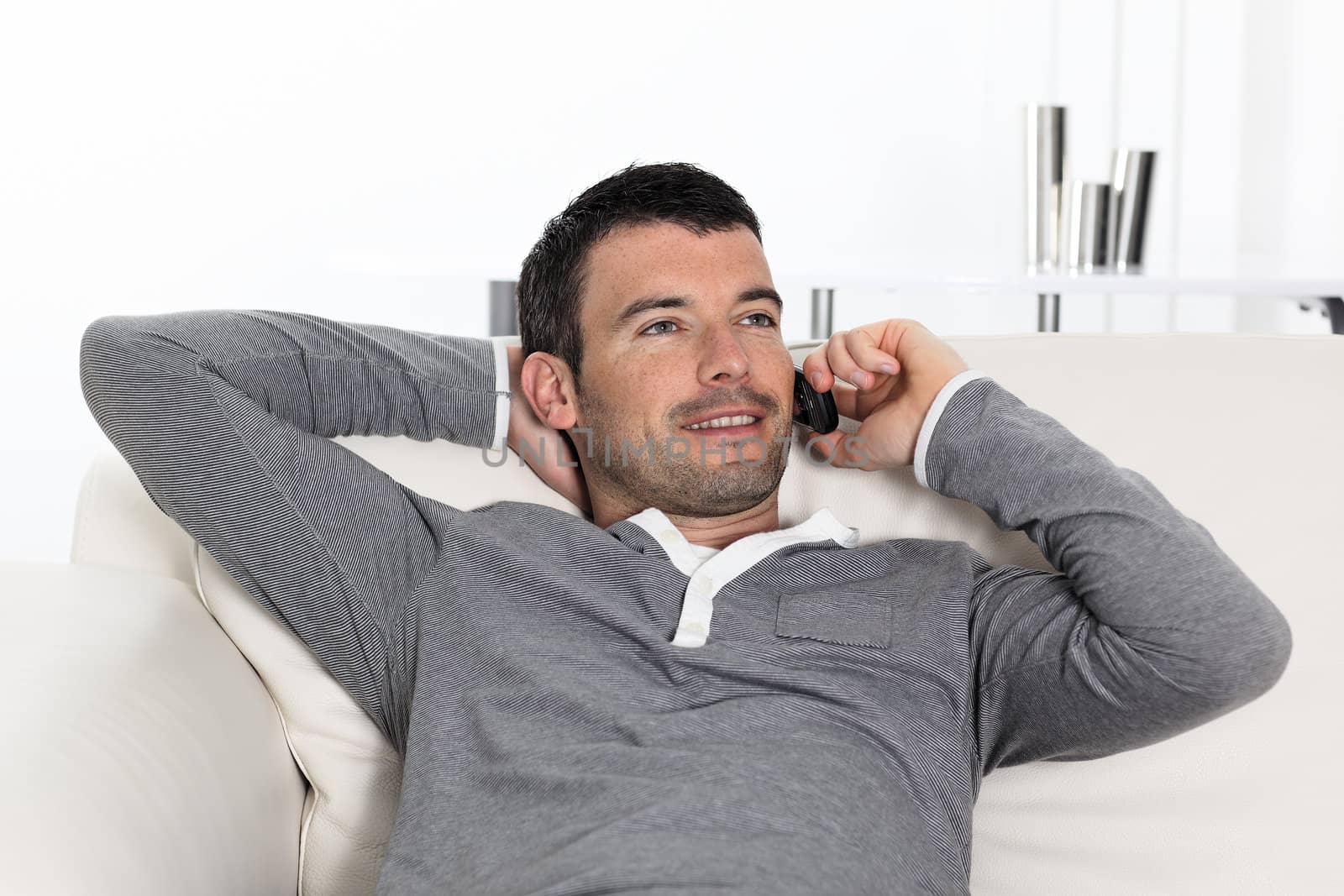 handsome man on the phone at home on sofa