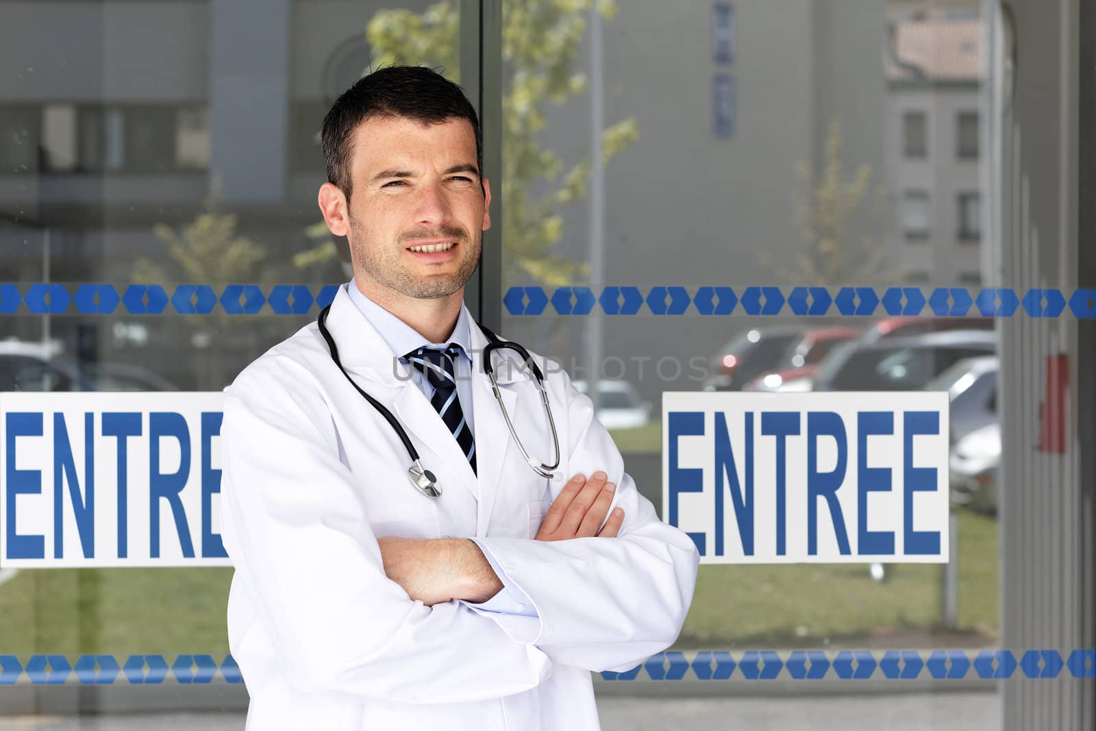 handsome doctor in front of hospital entry