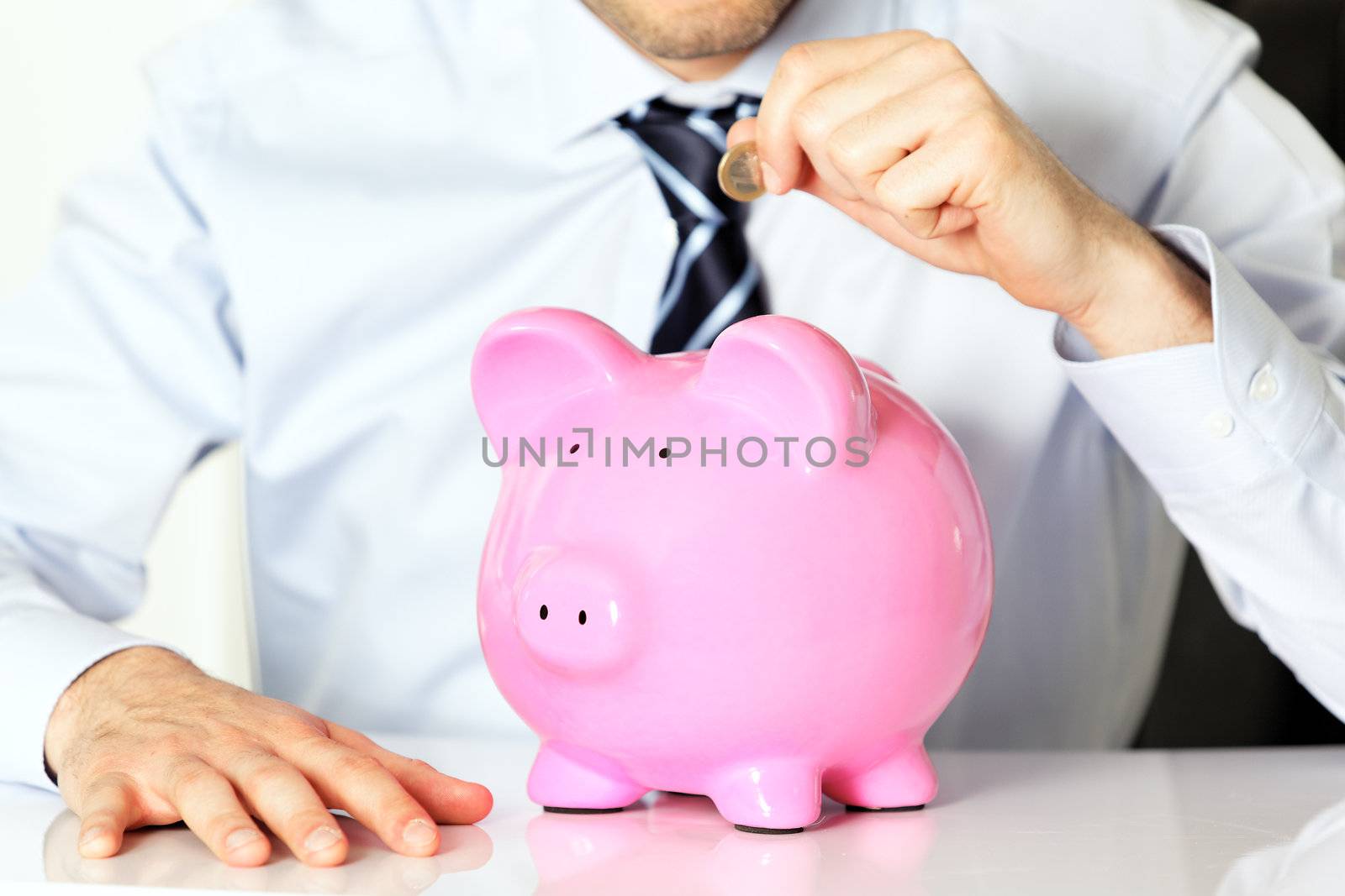 businessman with coin and pink piggy bank