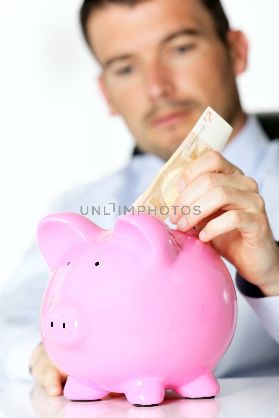 hand of man with bill and pink piggy bank 