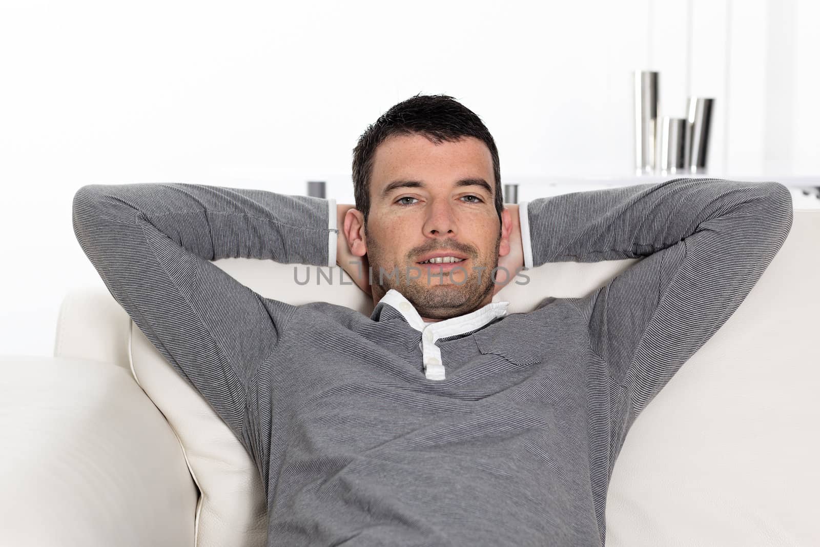 relaxed man sitting on sofa at home