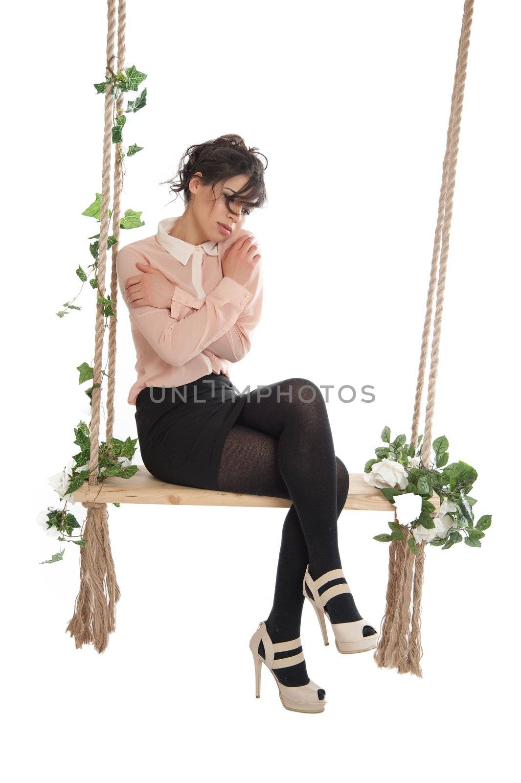 Emotional woman on a swing in the studio isolated background