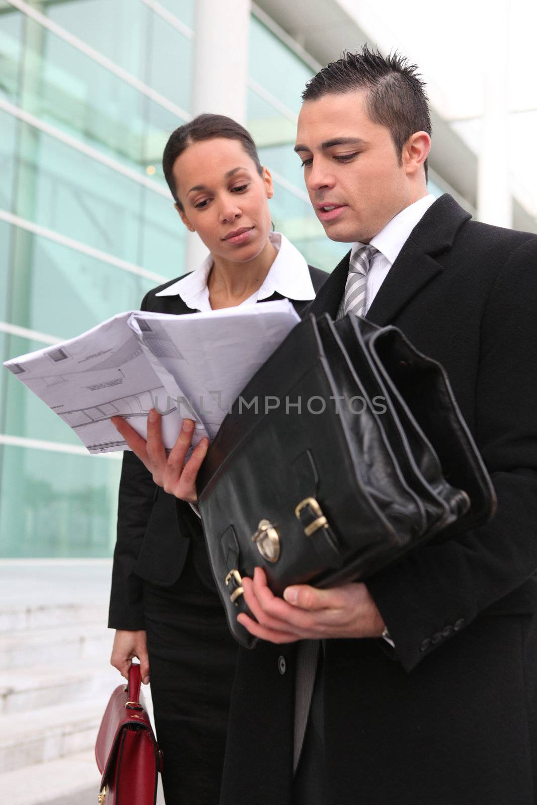 Businesspeople looking at a plan outdoors