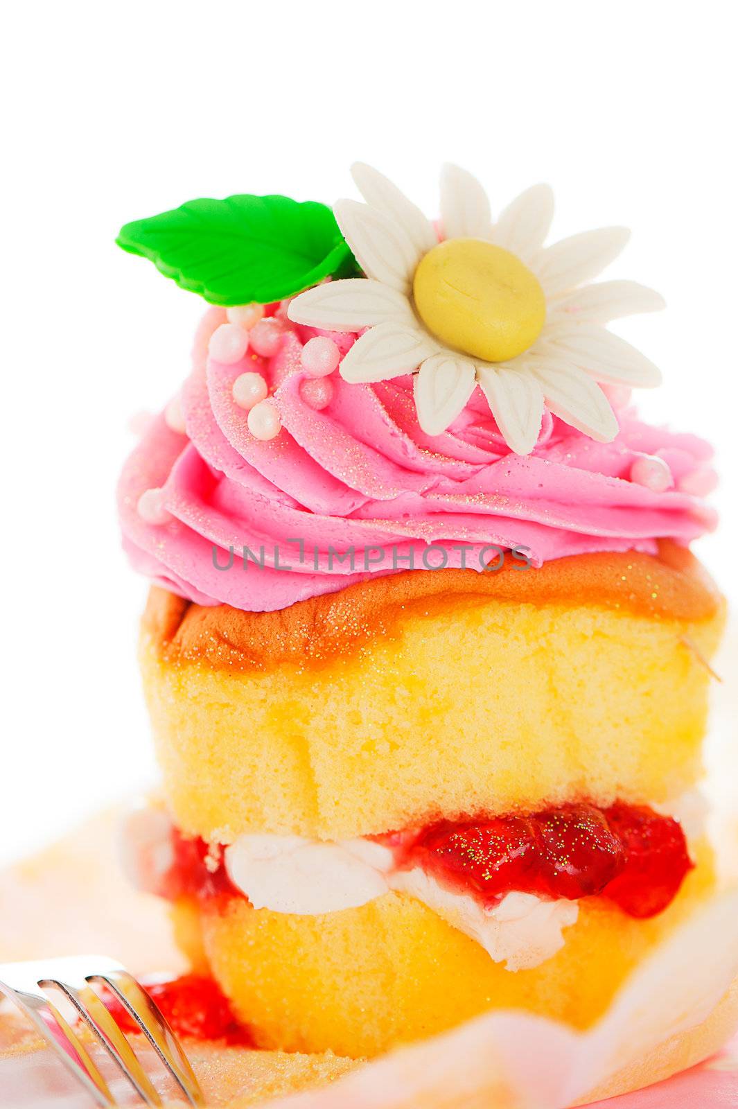 A two layer cupcake with pink and white buttercream sugar flower and gold powder on a white background as a studio shoot