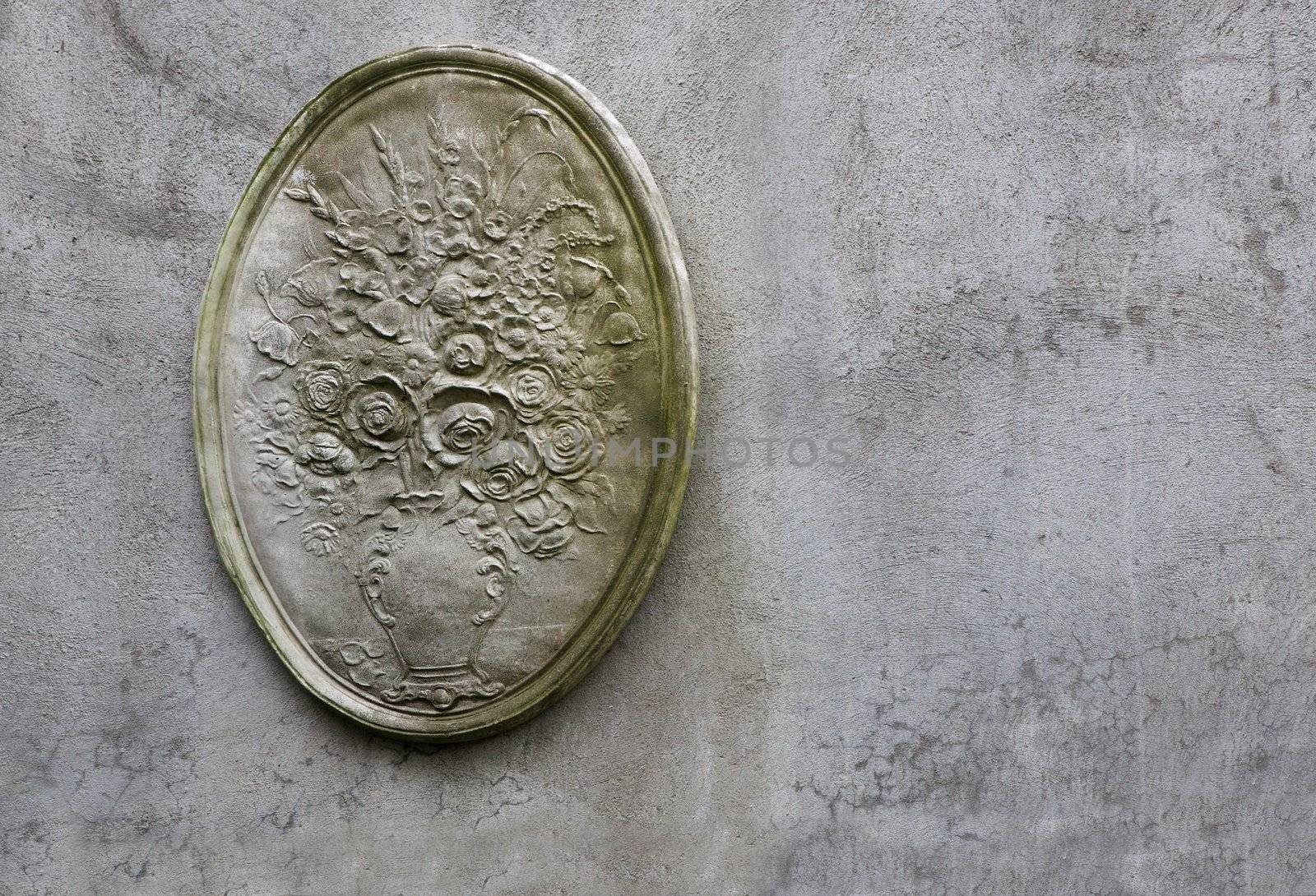 Victorian style plaster flower pot design on a concrete wall