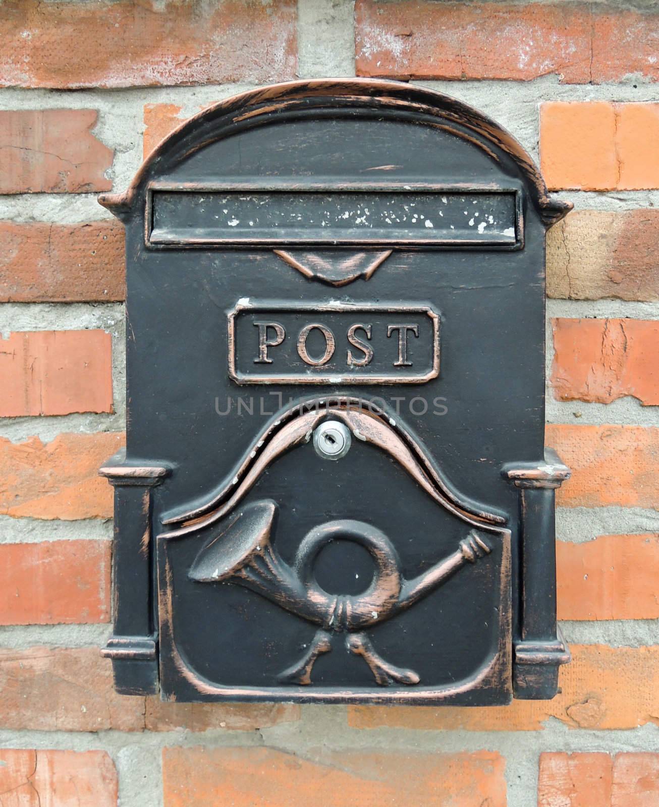 Black mailbox on brick wall by MalyDesigner