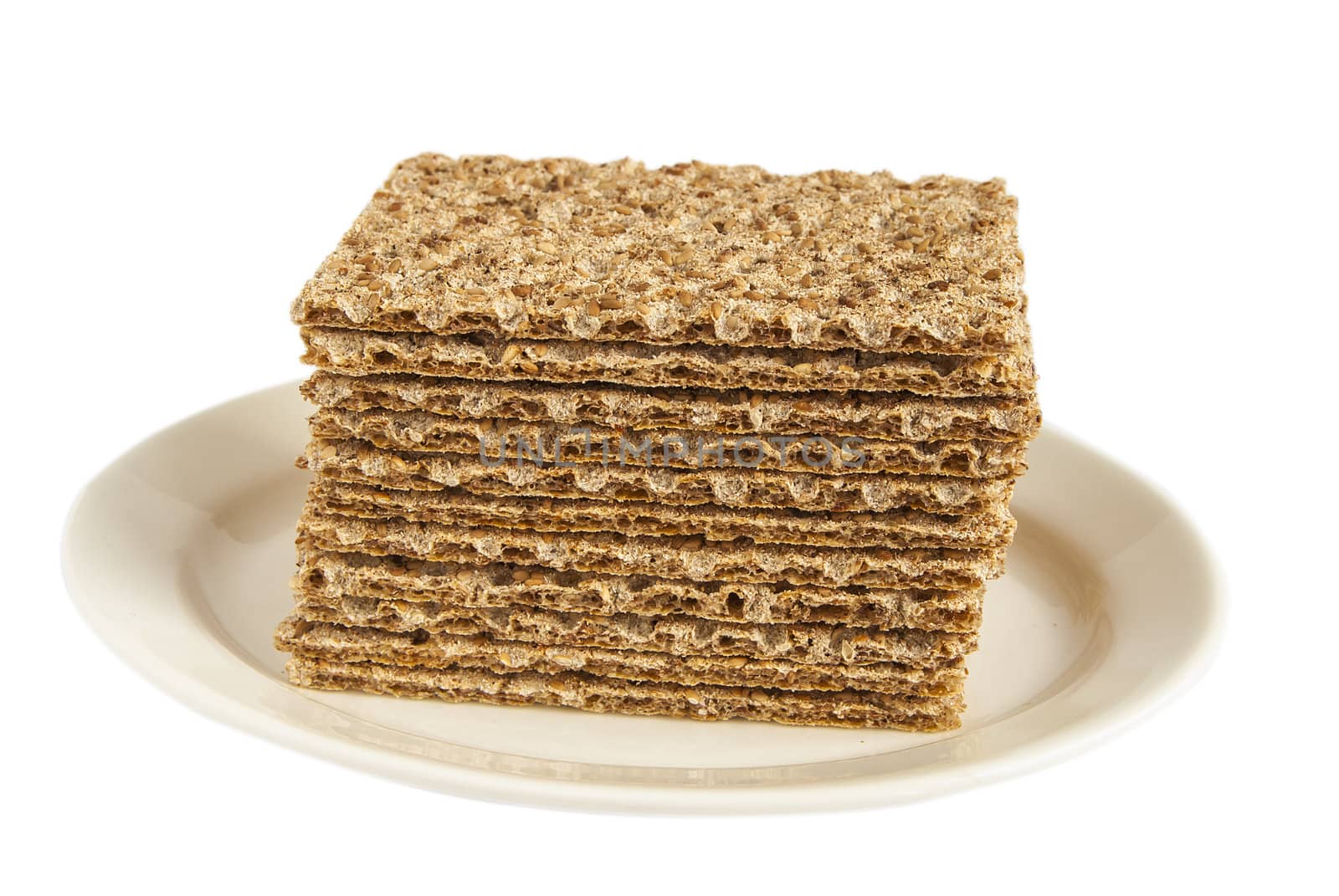 Sesame wholegrain crispbreads on porcelain plate isolated on white background